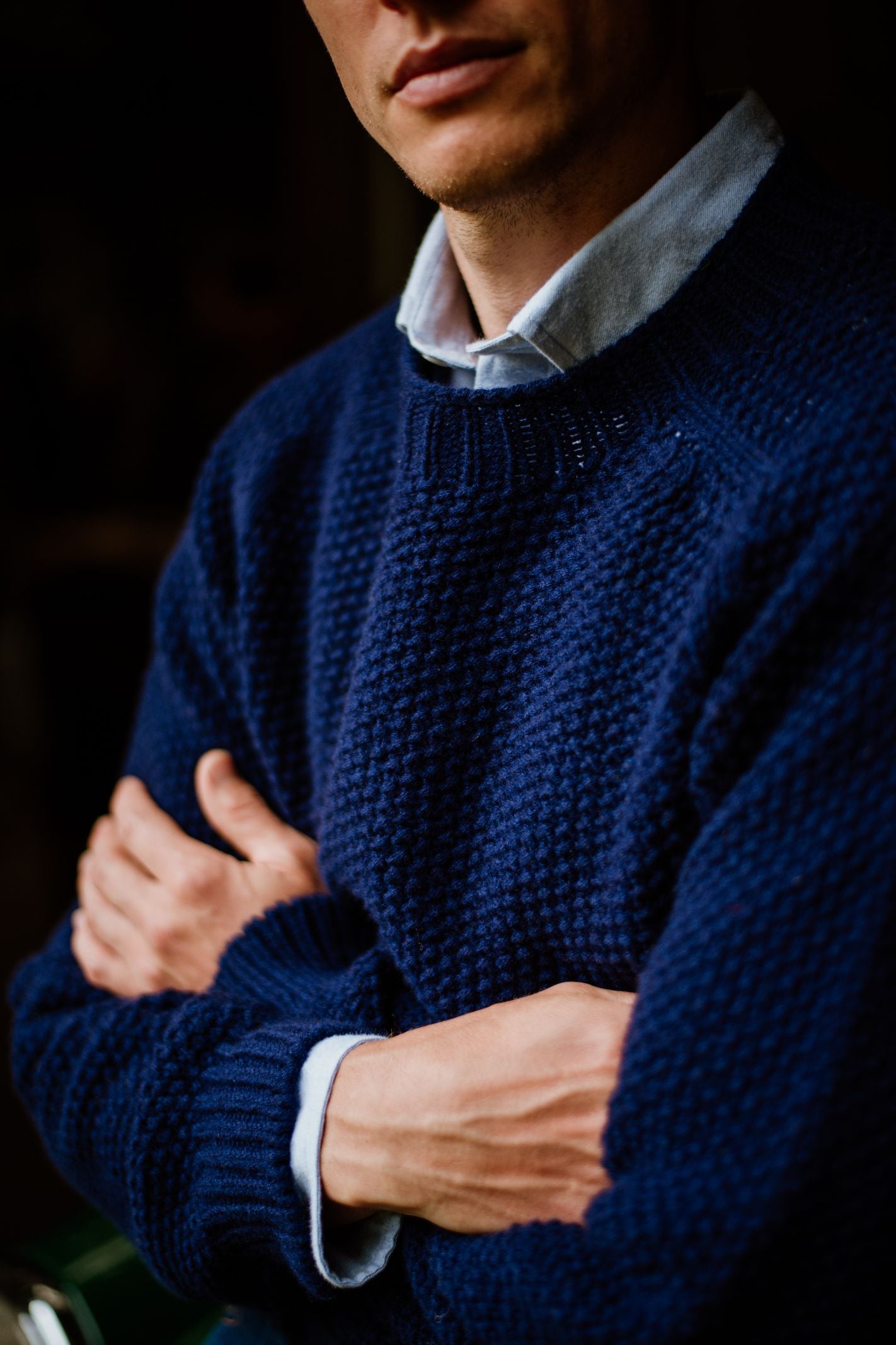 A person wears the Campbells of Beauly Geelong Lambswool Chunky Crew Jumper in navy over a light blue collared shirt, standing with arms crossed, showing only the lower face and upper body.