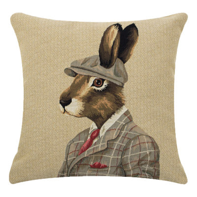 The Dapper Hare Cushion Cover by Campbells of Beauly features a serious hare in a plaid suit, red tie, and gray cap. This beige needlework cover brings whimsical, anthropomorphic charm to your home decor.