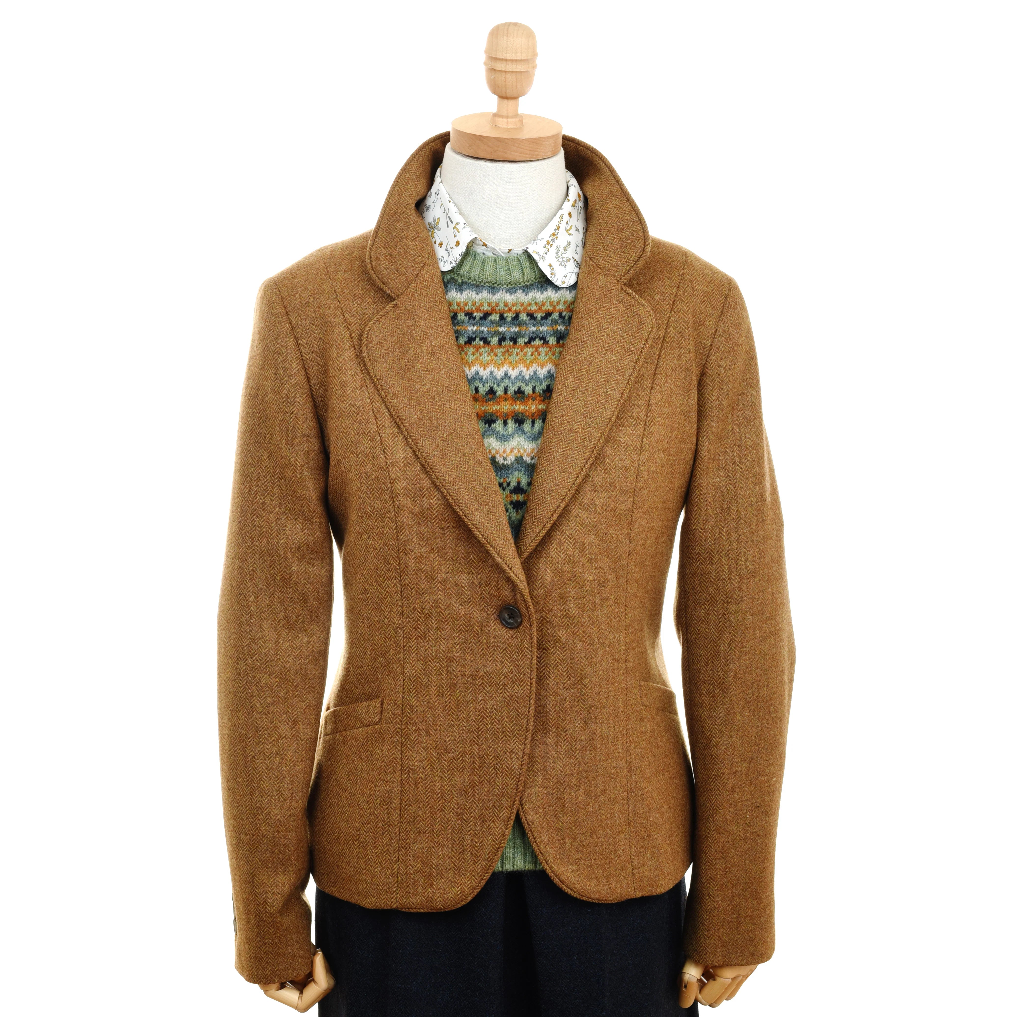 A mannequin sports Campbell's of Beauly’s gold House Jacket with a single button and notched lapels, layered over a patterned sweater and white collared shirt, paired with dark pants.