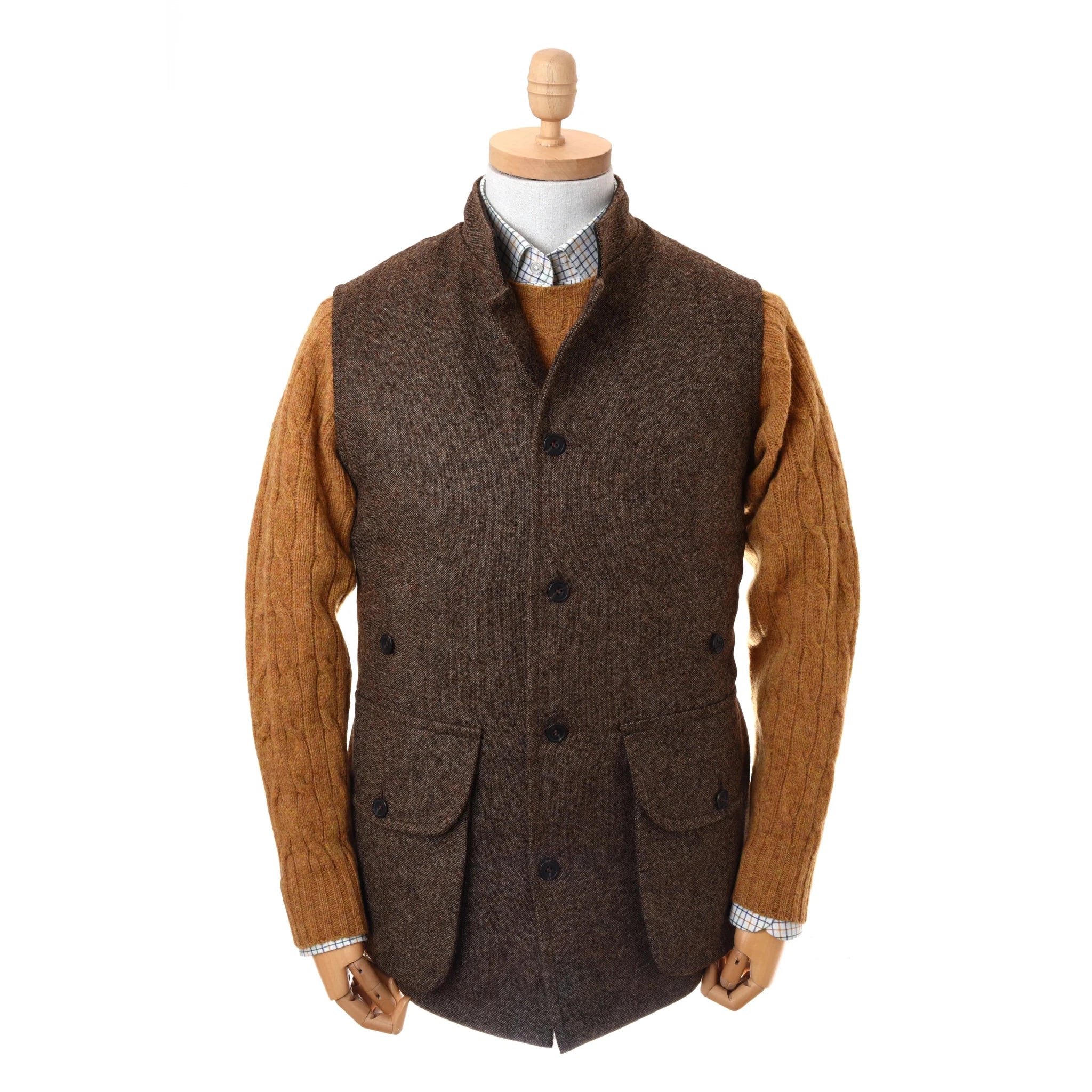 A mannequin wears Campbell's of Beauly Auld Stock Field Nehru Gilet—brown British moleskin with black buttons, quilted lining, and two large pockets—over a mustard cable-knit sweater and checkered collared shirt.