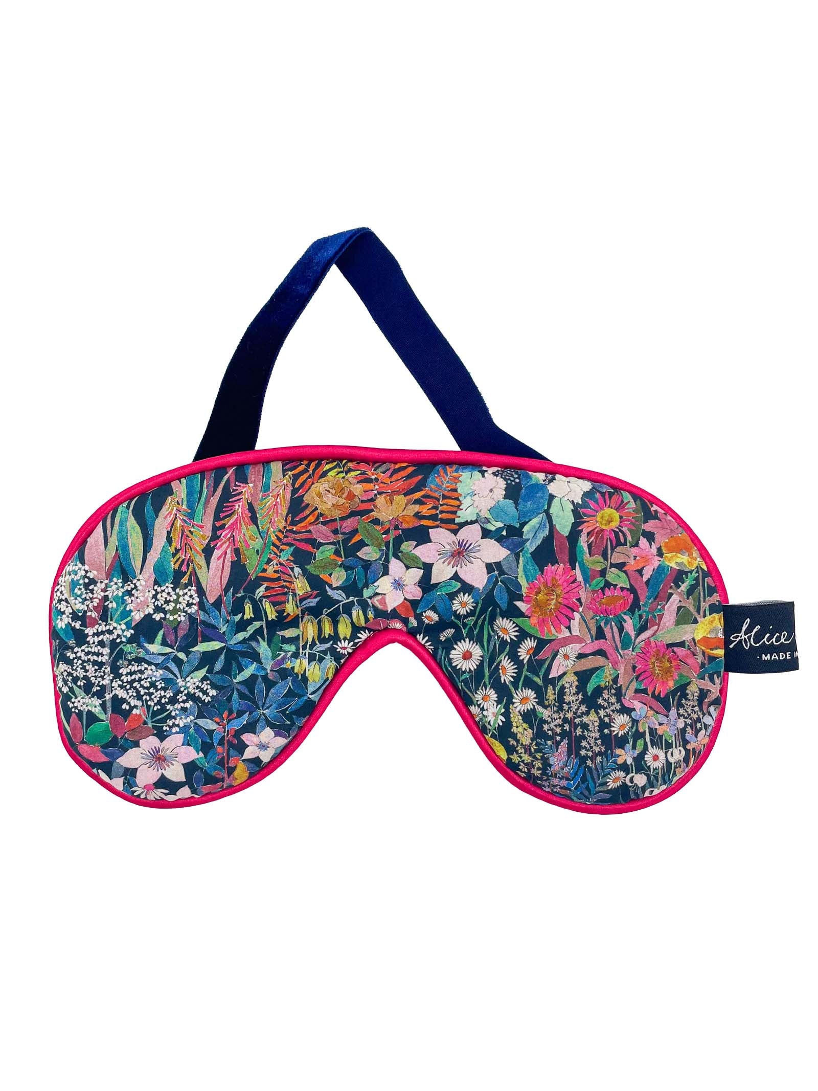 A vibrant Liberty Print Eye Mask in the Faria floral pattern by Alice Caroline, featuring pink trim, a dark blue strap, and a small "Alice Made" tag.