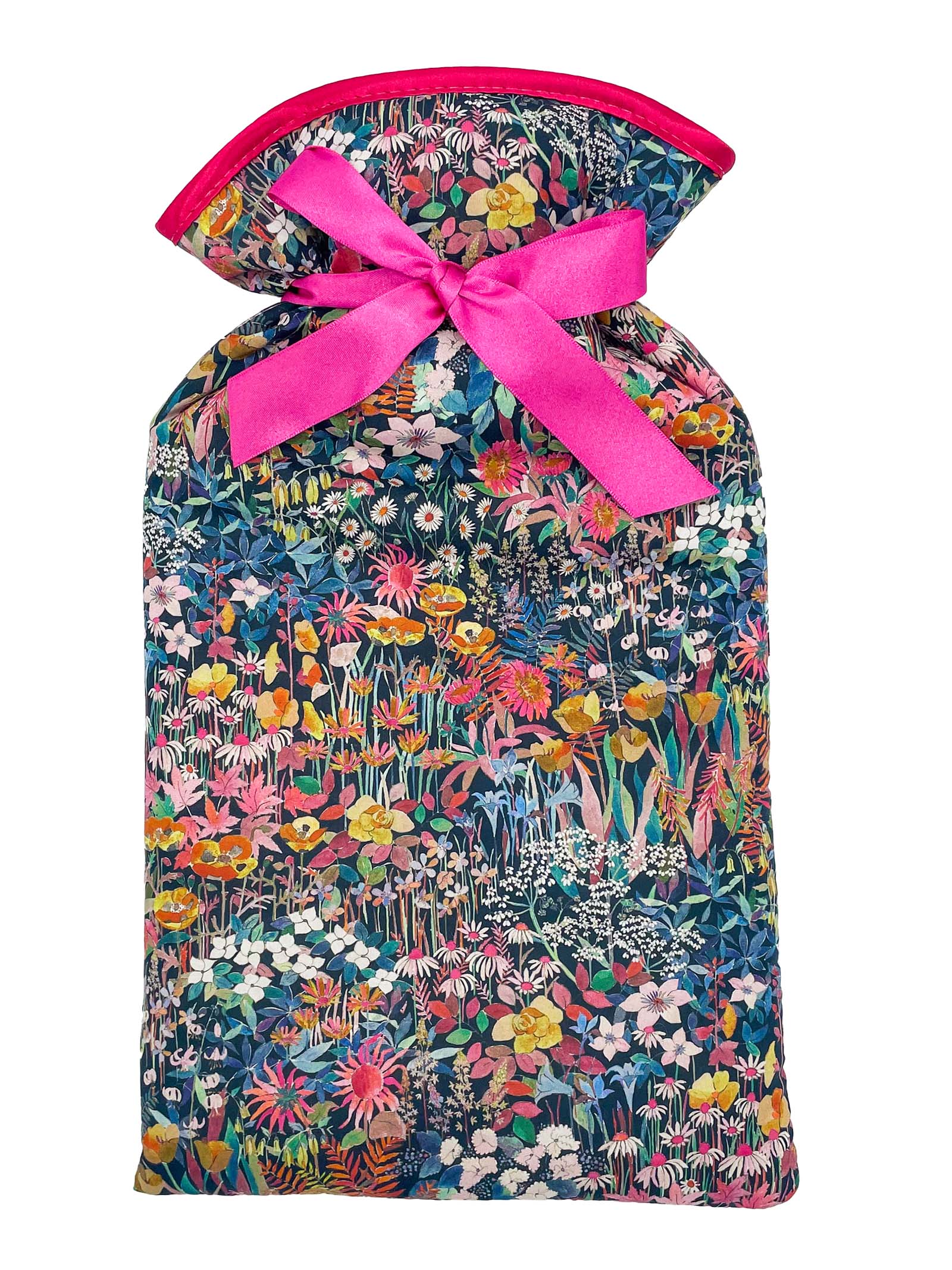The Alice Caroline Liberty Print Hot Water Bottle in Faria features a vibrant, densely floral Liberty cotton bag and a bright pink bow, with flowers and leaves in pink, yellow, green, and blue. Perfect for keeping your hot water bottle stylishly cozy.