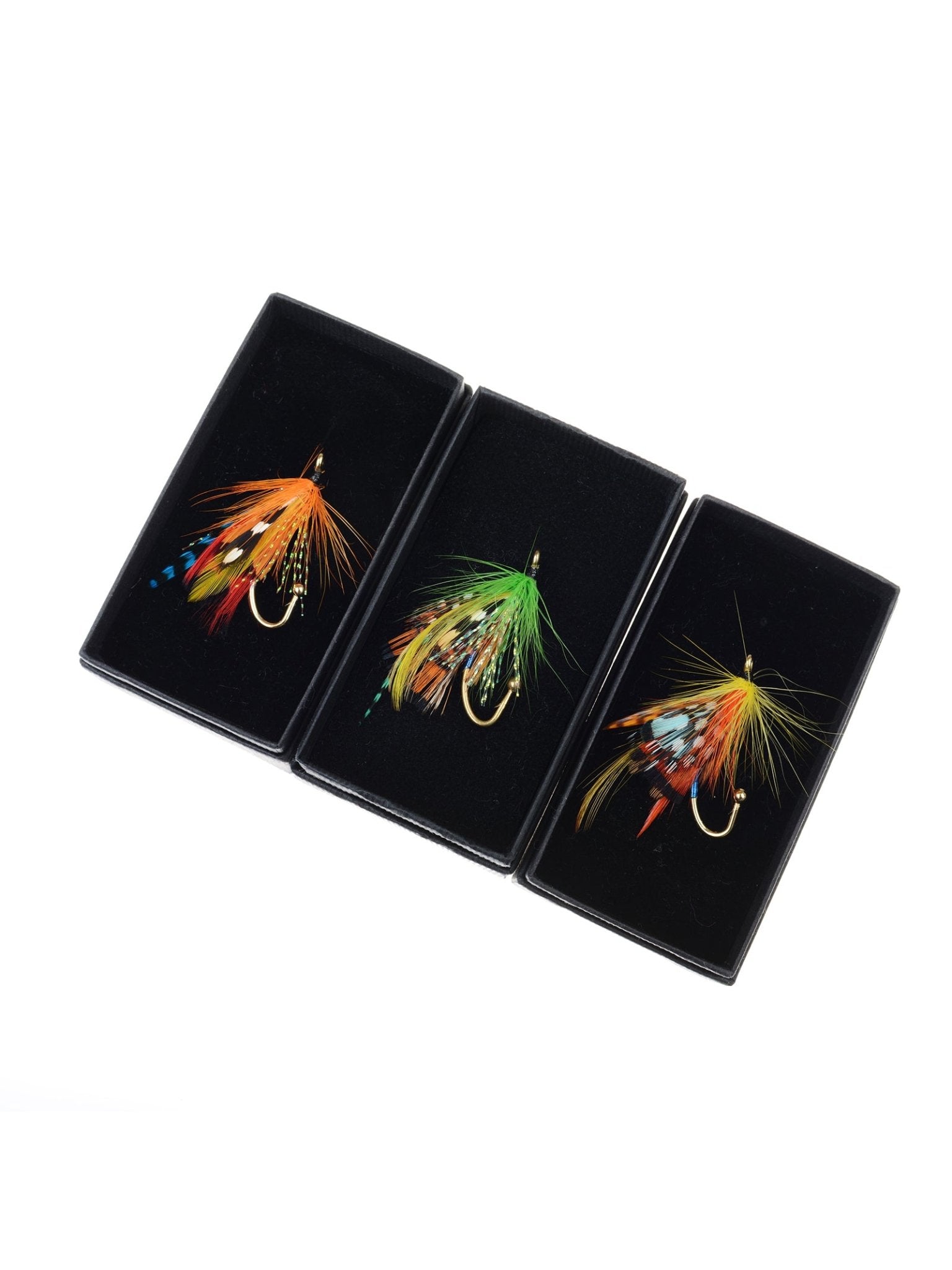 Three Campbell's of Beauly Fly Fishing Brooches, each featuring vibrant orange, green, and yellow feathers, are presented in black boxes on a white backdrop—unique handmade accessories that add country charm to any outfit.