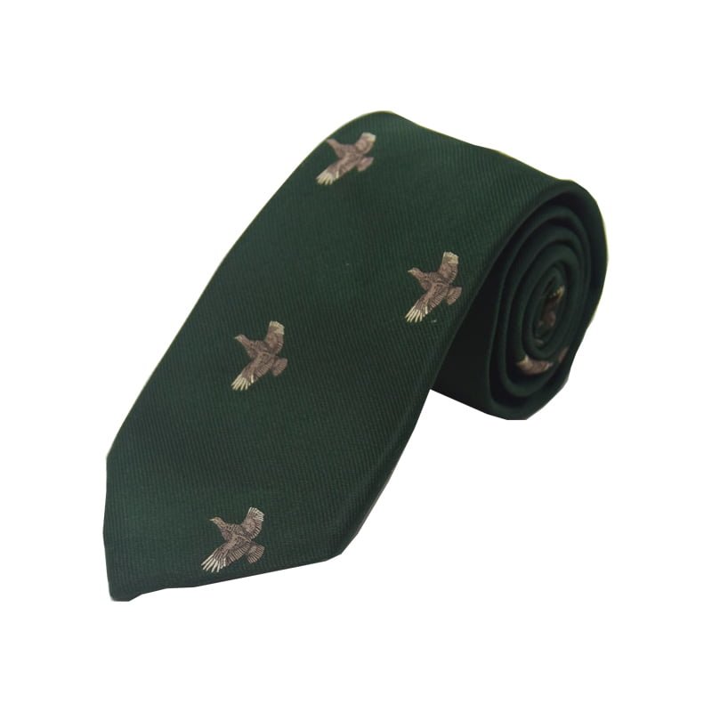 The Full Flight Grouse Silk Tie by Campbells of Beauly features a green silk fabric embroidered with flying birds in a countryside motif, shown rolled up on a white background.