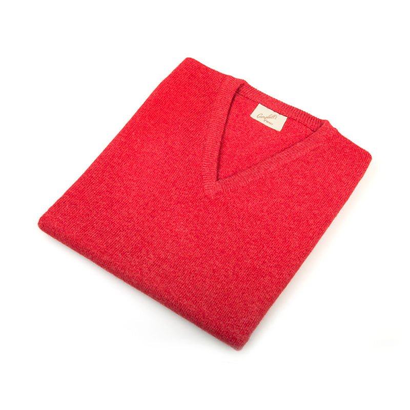 A neatly folded Campbells of Beauly Cashmere Slipover in cardinal, a timeless layering piece with a visible beige tag, placed on a white background.