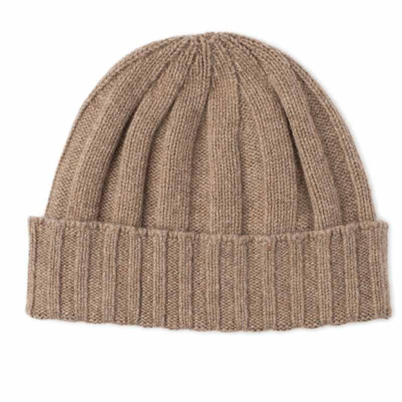 The Cashmere & Merino Rib Beanie by Campbells of Beauly comes in a natural hue, featuring a ribbed texture and folded brim. Crafted from soft merino wool and cashmere, its an essential accessory for cold weather.