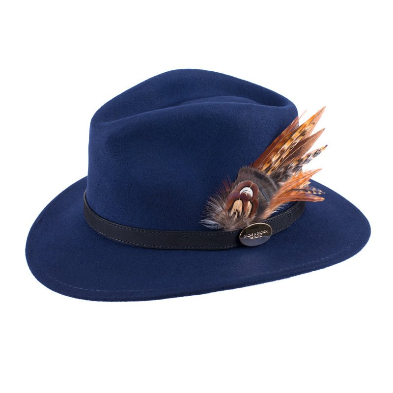 The Hicks & Brown Gamebird Fedora in navy wool felt features a black band and a decorative cluster of brown and orange feathers on the side.