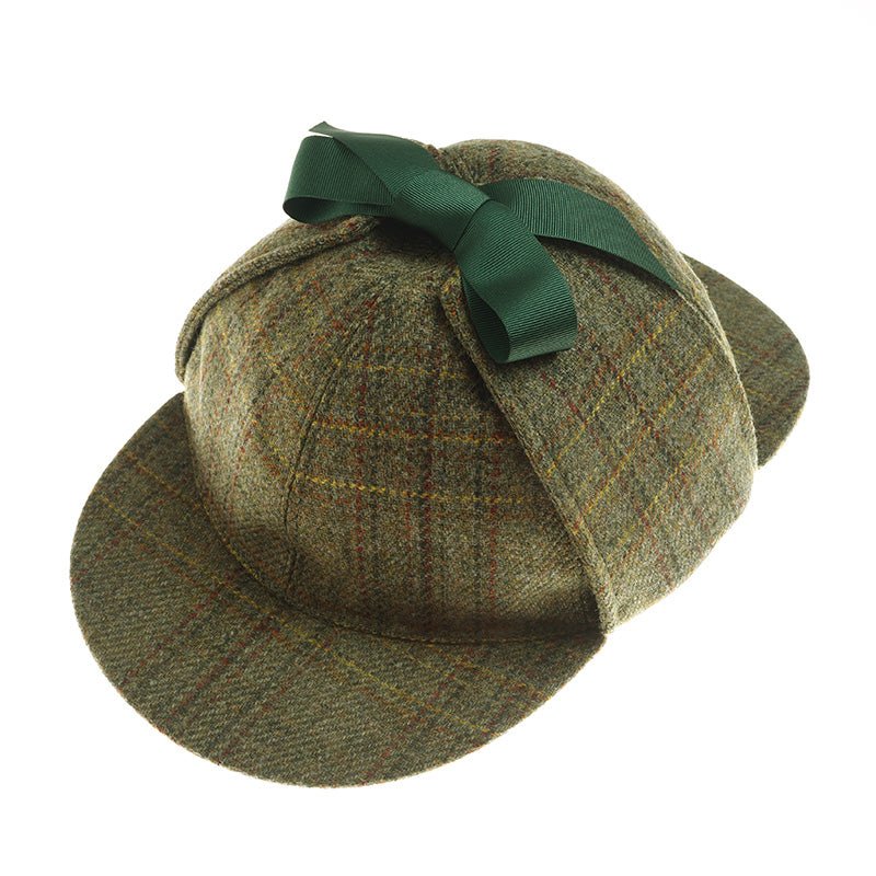 The Sherlock Holmes Hat by Campbells of Beauly features brown and green plaid, a green ribbon bow on top, dual brims front and back, and classic earflaps for added style.