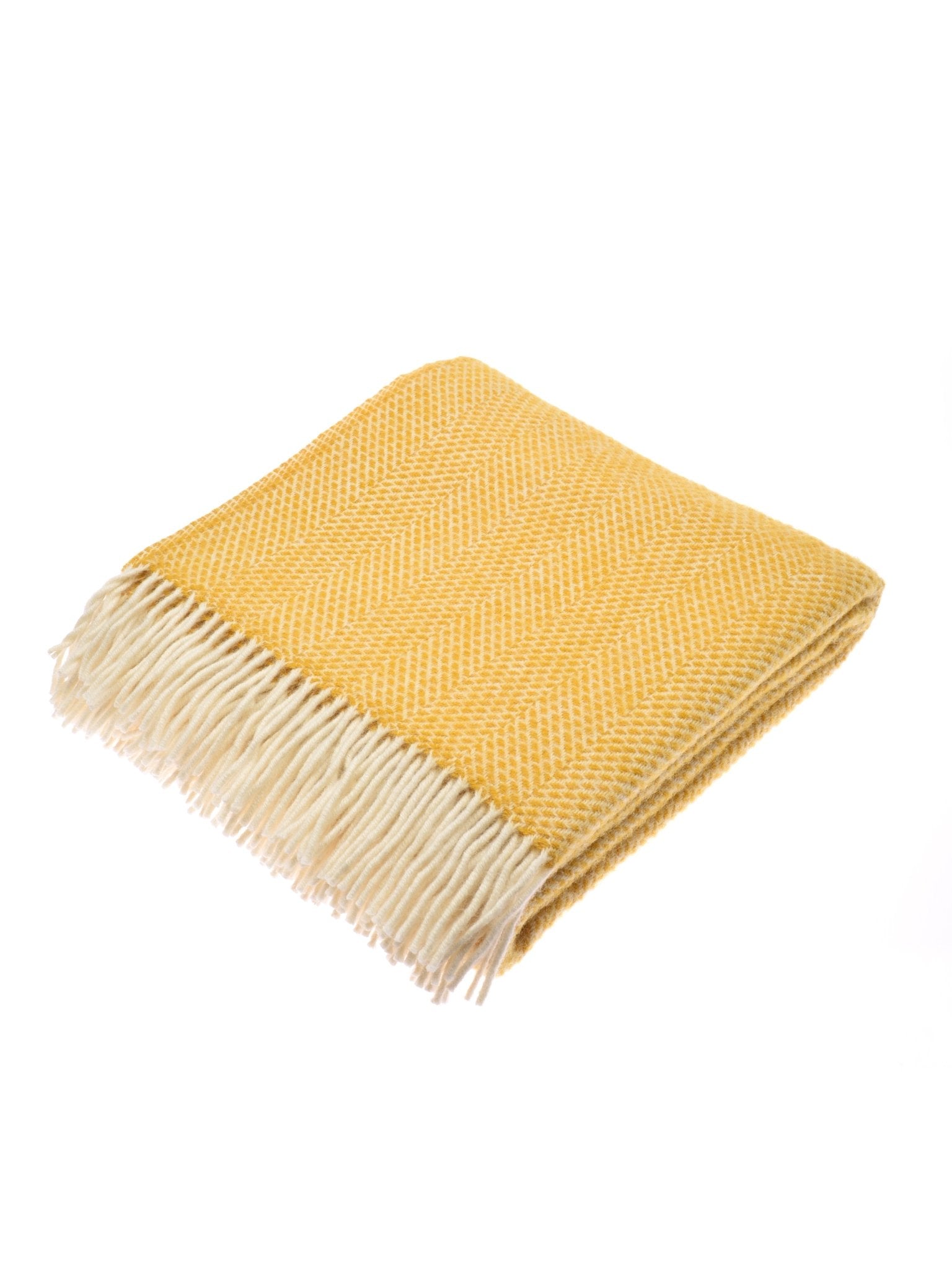The Campbells of Beauly Stipled Twill Blanket in Wild Gorse is a lightweight folded blanket with a subtle herringbone pattern and white fringe, shown on a white background.