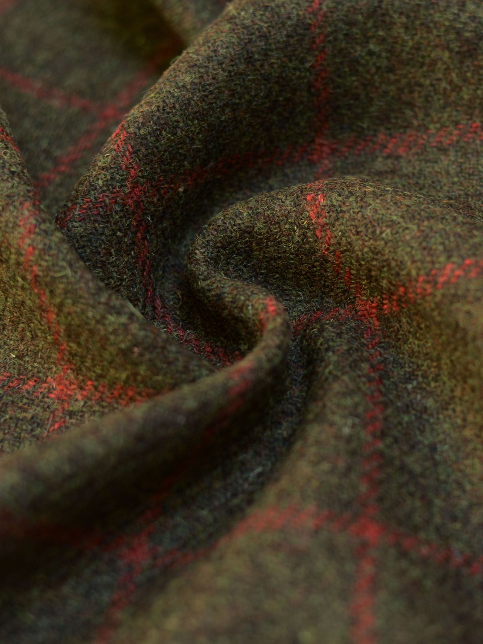 Close-up of House Tweed 93907 by Campbell's of Beauly—brown wool tweed fabric with a red plaid pattern, highlighting its soft texture and gentle folds.
