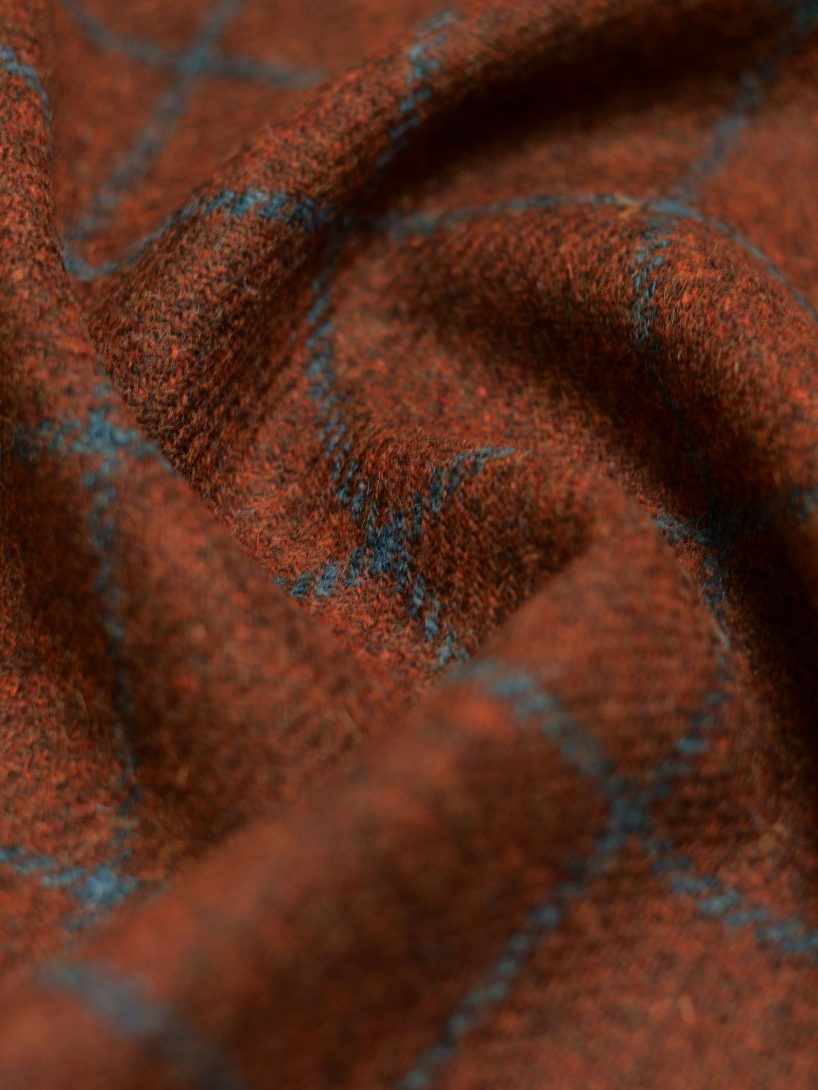Close-up of House Tweed 93903 by Campbell's of Beauly—a soft, textured brown fabric with a blue plaid pattern, draped to highlight its classic Scottish tailoring and timeless Harris Tweed elegance.