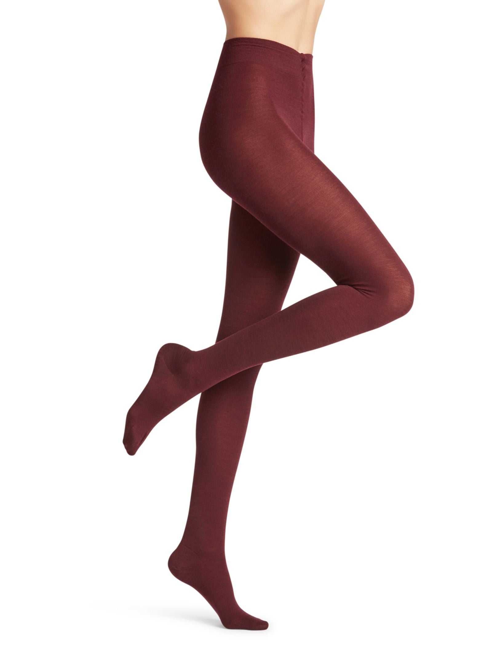 Model showcases FALKE Merino Tights in opaque burgundy, posing with one leg bent and raised to highlight the fit and rich color of the merino wool. The upper body is not visible against the white background.