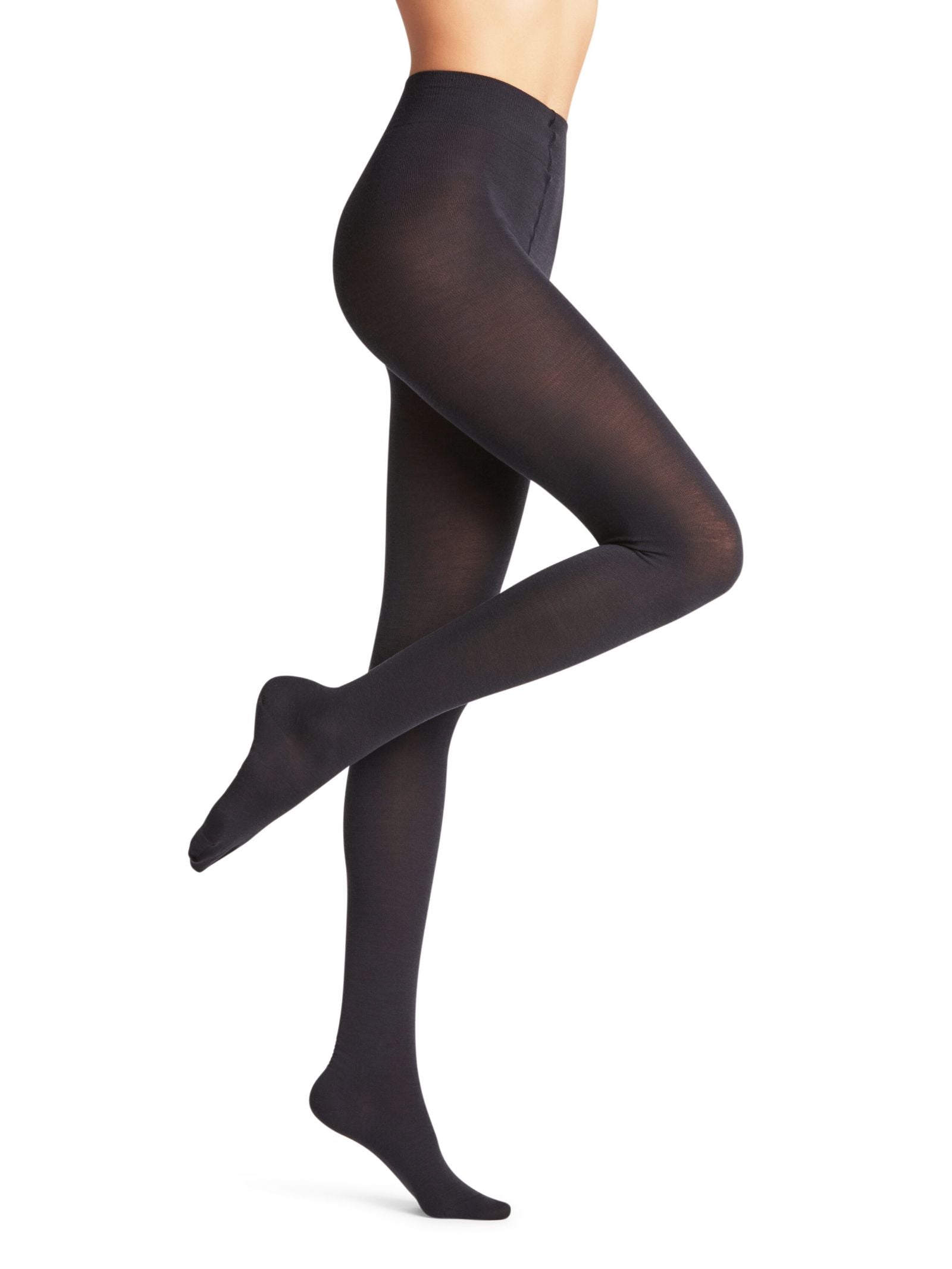 A person models FALKE Merino Tights in black, standing on one leg with the other knee bent and toes pointed, against a plain white background.