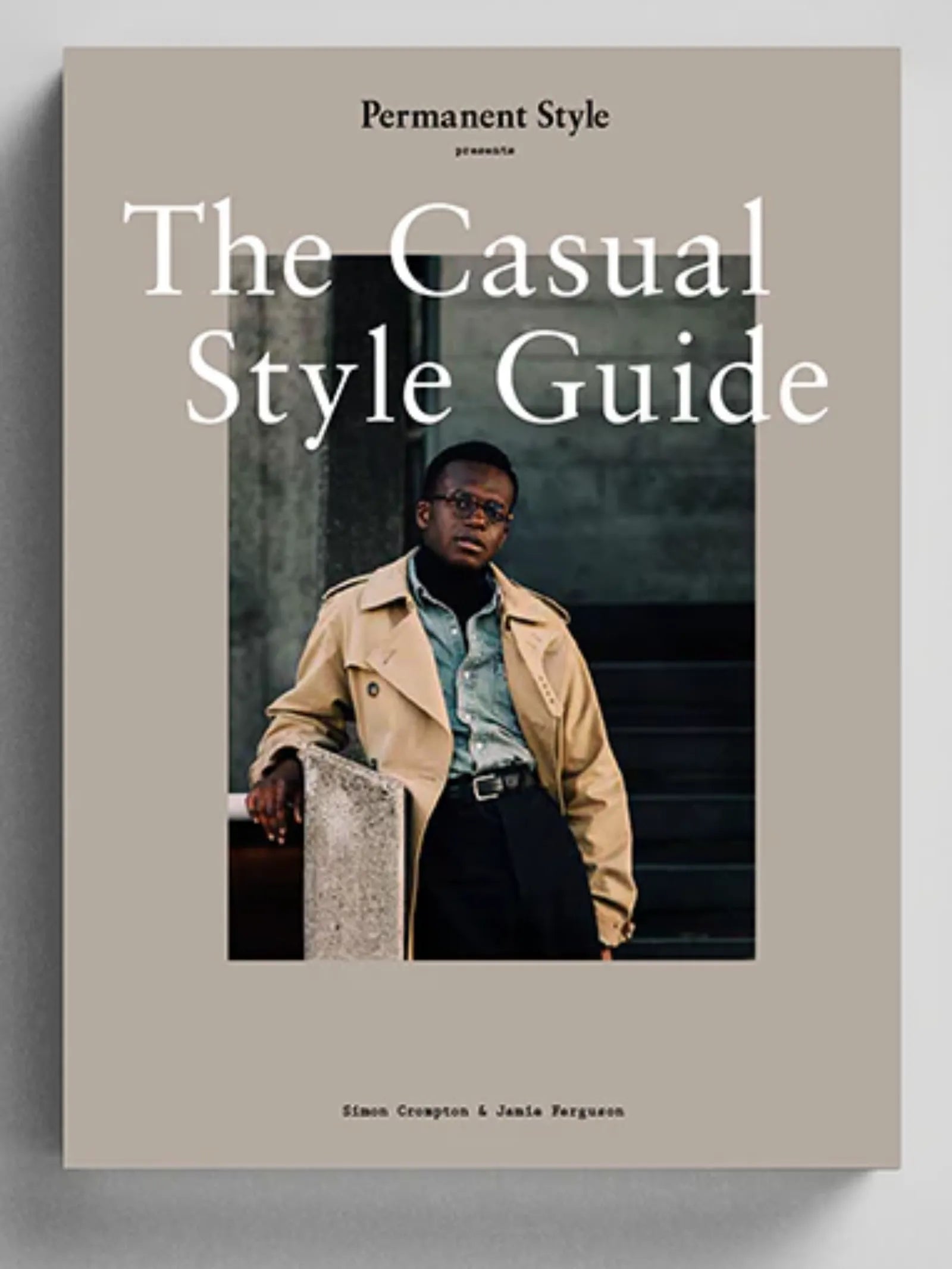 The Casual Style Guide by Permanent Style features a menswear look—a tan trench coat, green shirt, and glasses—against a neutral background, highlighting street-style fashion.