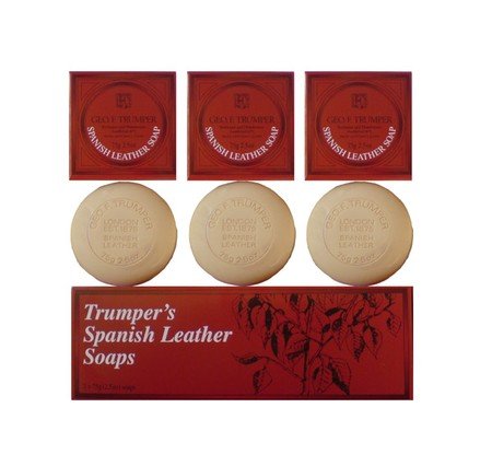Three round, triple-milled soaps from Geo. F. Trumper’s Spanish Leather Hand Soap, Set of 3, are displayed above three elegant red boxes featuring the iconic floral design and the label “Trumpers Spanish Leather Soaps.” Perfect for guest bathrooms, these luxurious soaps offer a classic aroma and a sophisticated presentation for any refined space.