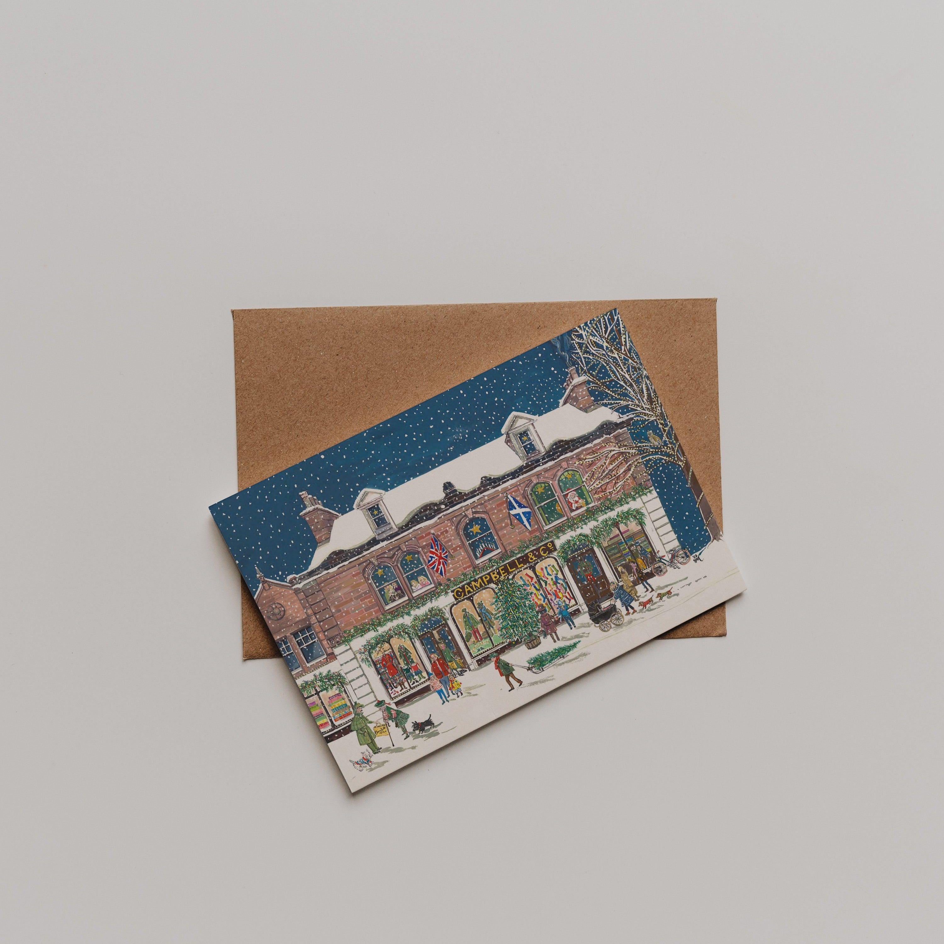 The Campbells at Christmas Greeting Card by Campbells of Beauly features a snowy holiday scene with decorated windows, people, and dogs. Perfect as a thank you note, it comes with a brown envelope and depicts snow falling against a dark blue sky.