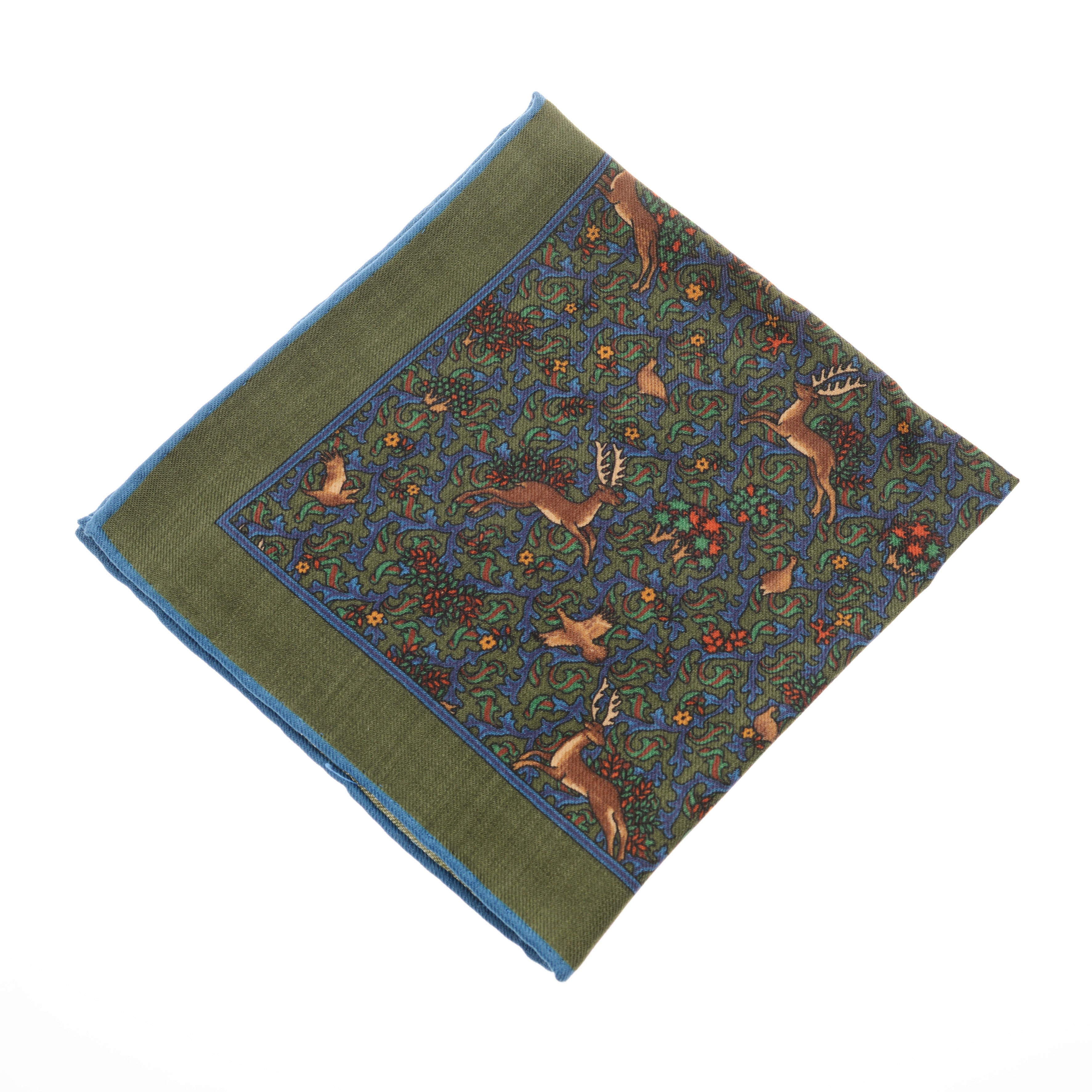 The Wool Hank by Campbells of Beauly is a square pocket square with a green background, blue border, and an intricate pattern of deer, birds, and leaves in earth tones among red berries. Hand-rolled edges complete this timeless accessory.