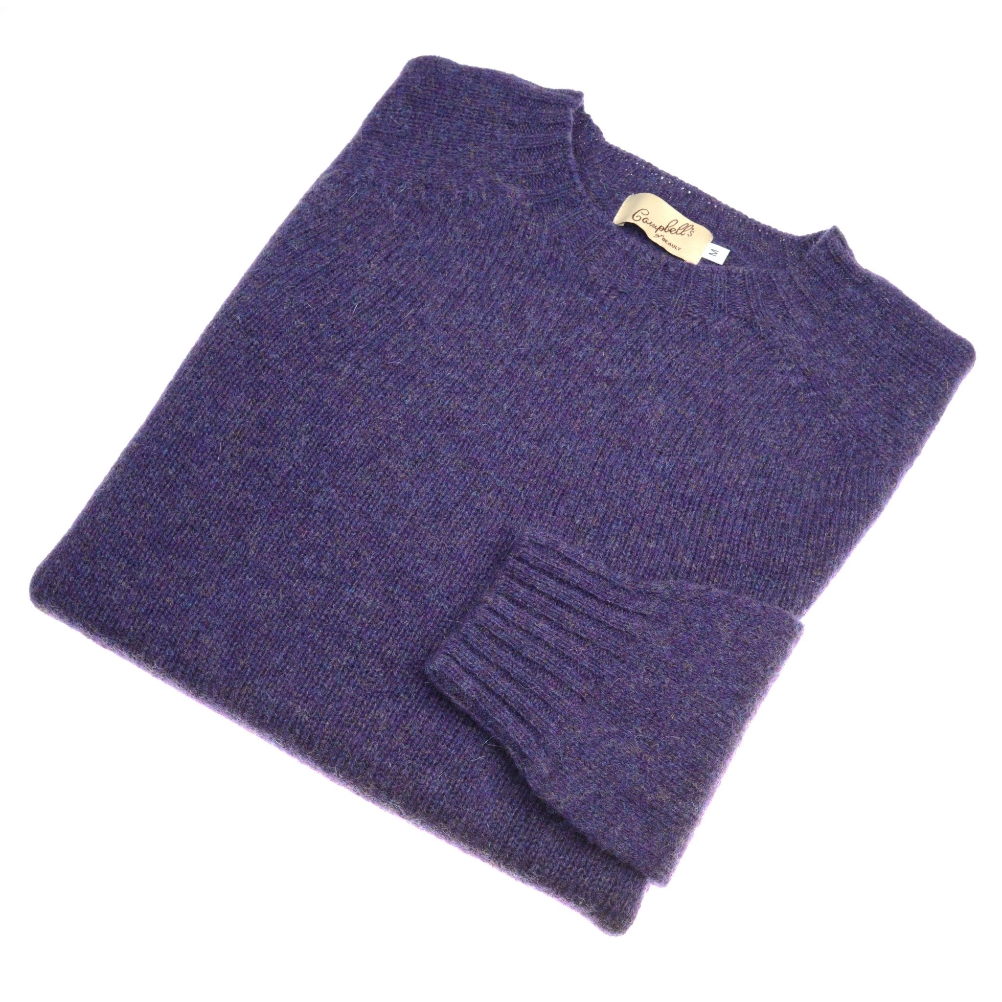 A folded blackberry Shetland Jumper sweater by Campbells of Beauly, featuring a visible ribbed cuff and neckline tag, crafted from lambswool yarns and displayed on a white background.