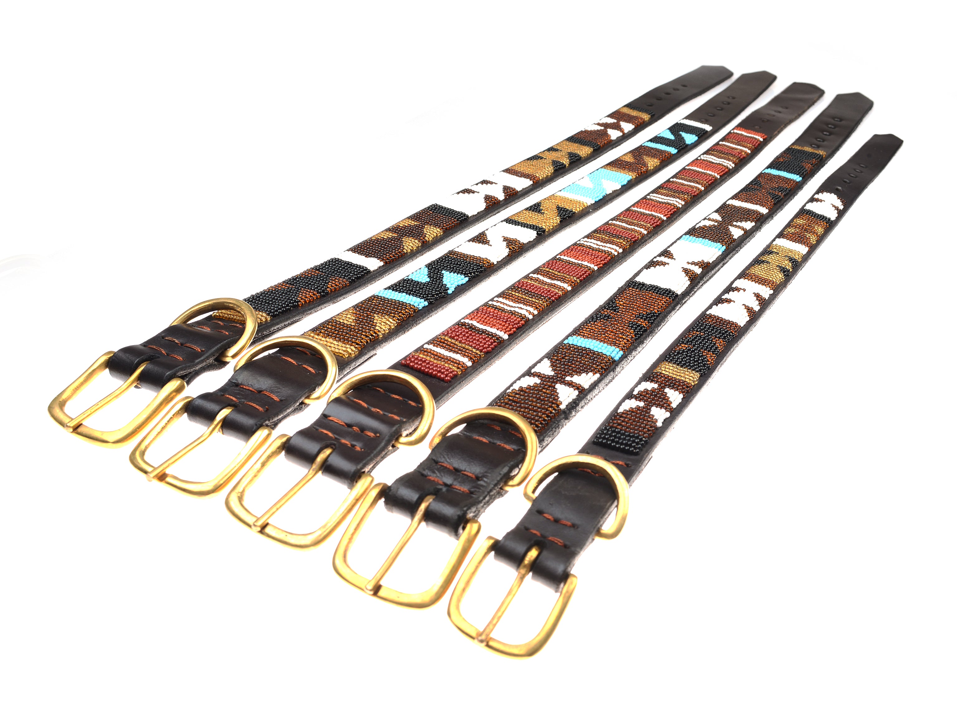 Five Campbells of Beauly dog collars with gold buckles are arranged side by side. Each collar, inspired by Masai women of Kenya, features unique beaded triangles and lines in brown, black, white, red, turquoise, and gold.