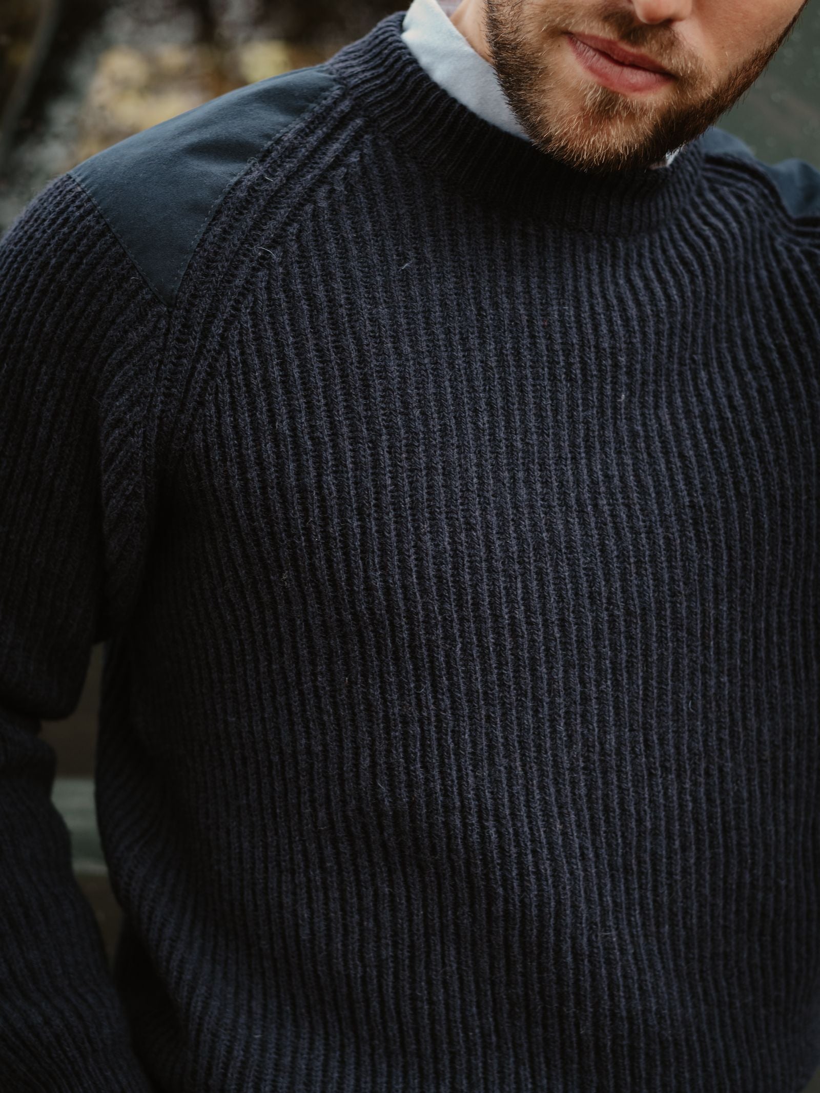 A close-up shows a man wearing Campbell's of Beauly's Scotia Suede Jumper over a light collared shirt. Only his lower face and torso are visible, highlighting the jumper’s rugged, outdoor-ready appeal.