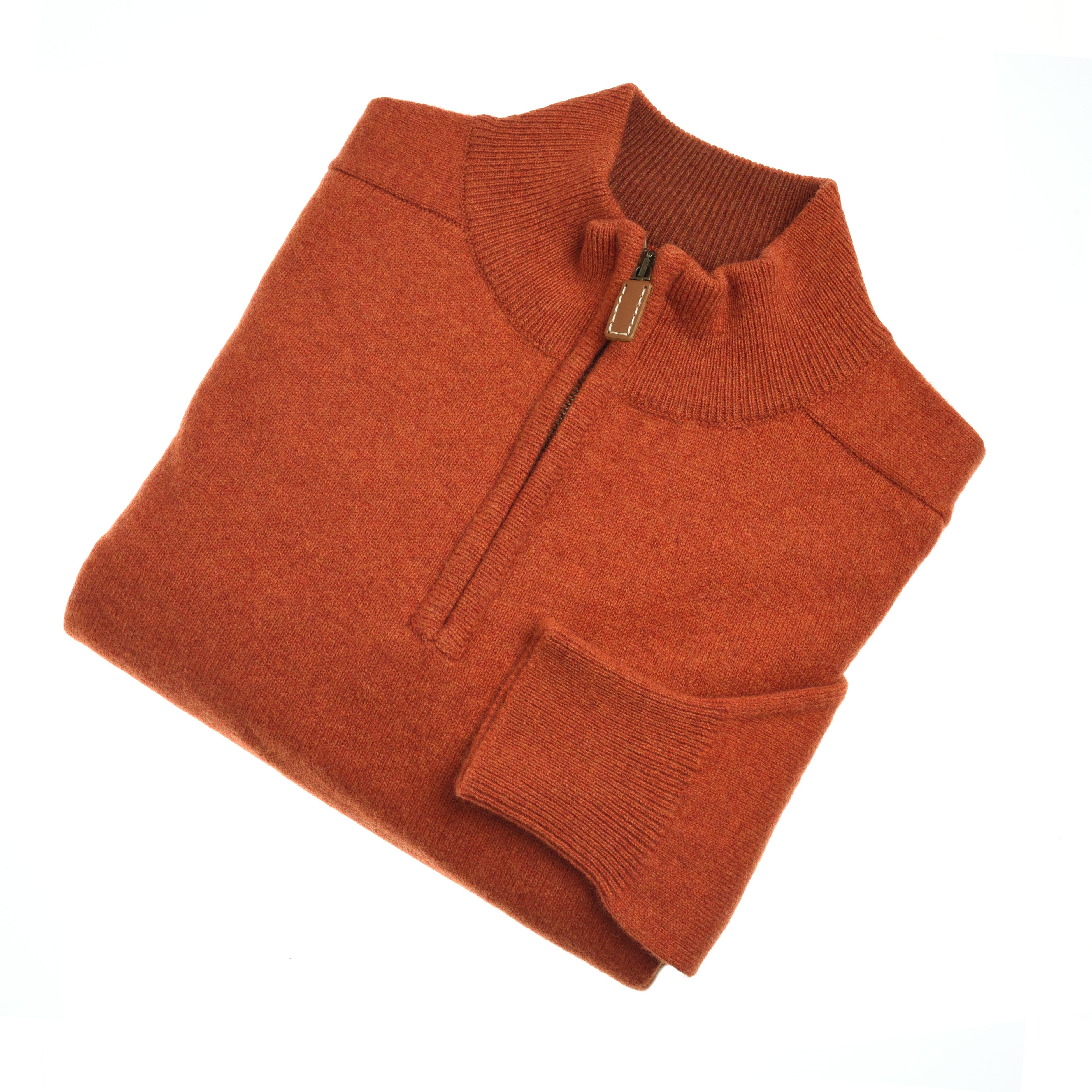 The Campbells of Beauly Lambswool Quarter Zip Jumper in burnt orange is folded neatly, showing its ribbed collar, cuffs, and hem with a short zip pull. The cozy jumper is set against a white background.