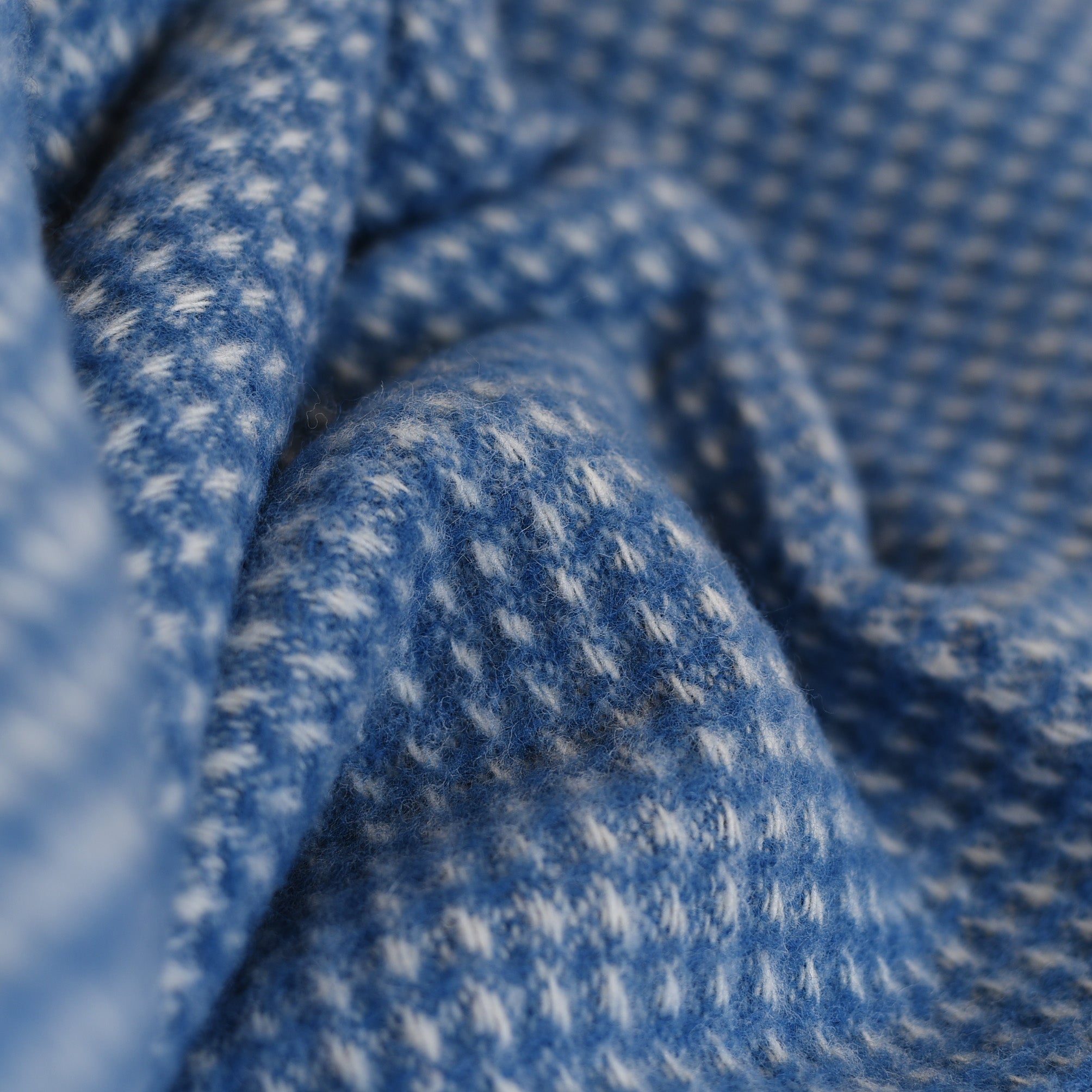 Close-up of the Honeycomb Lambswool Throw by Campbells of Beauly, showcasing its soft blue-and-white dots and subtle honeycomb weave—an inviting layer of warmth for your Yorkshire-inspired home.