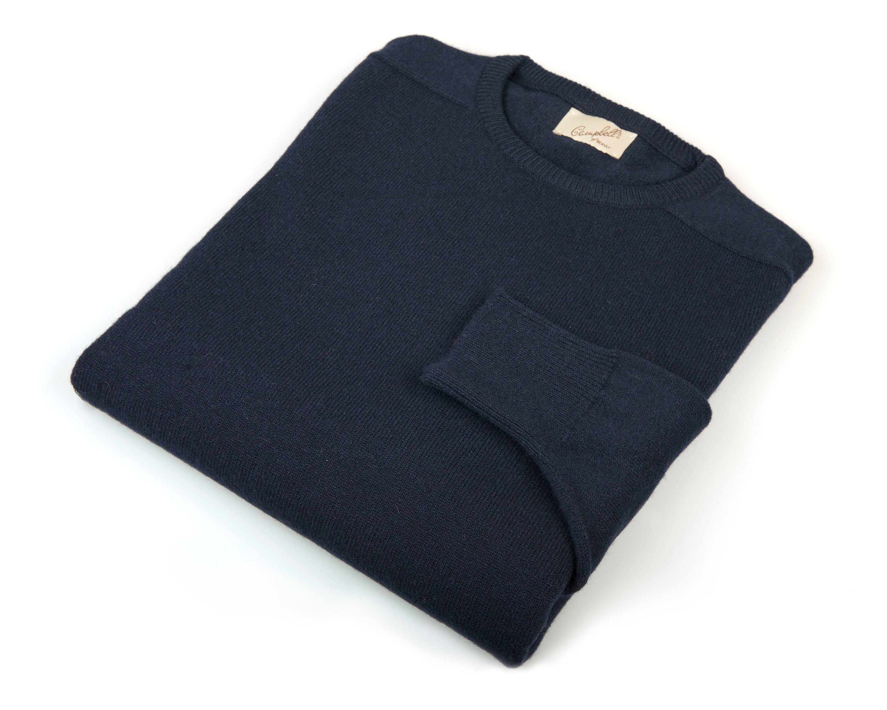 A neatly folded navy Lambswool Crew Neck Jumper by Campbells of Beauly, crafted from soft knit fabric. The left sleeve is partially folded across the front, with a beige branded tag at the neckline, set against a white background.