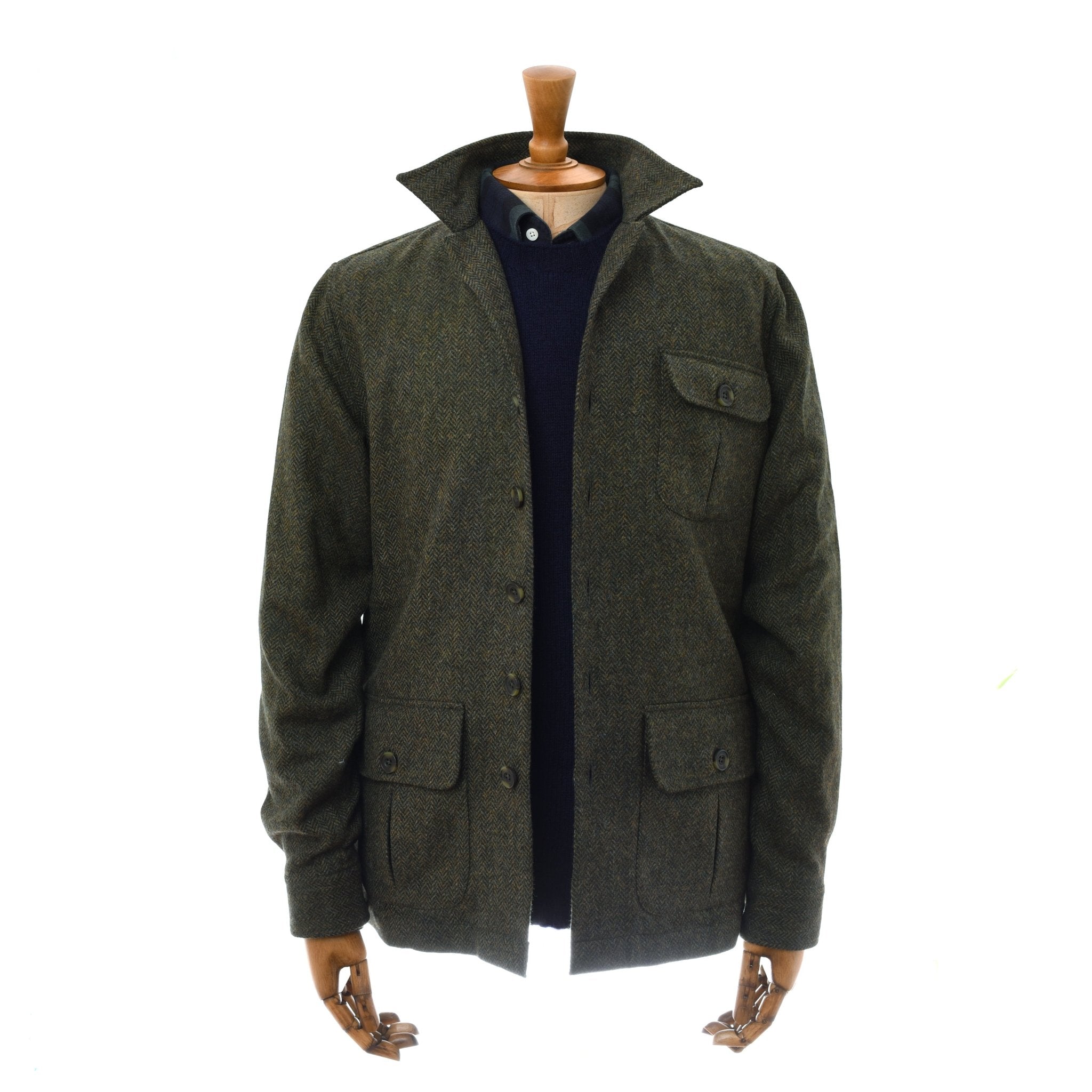 A mannequin wears Campbell's of Beauly Casual Shacket in Forest Herringbone, featuring relaxed tailoring, three front pockets, and a stand-up collar, layered over a navy sweater and collared shirt for an effortlessly refined style.