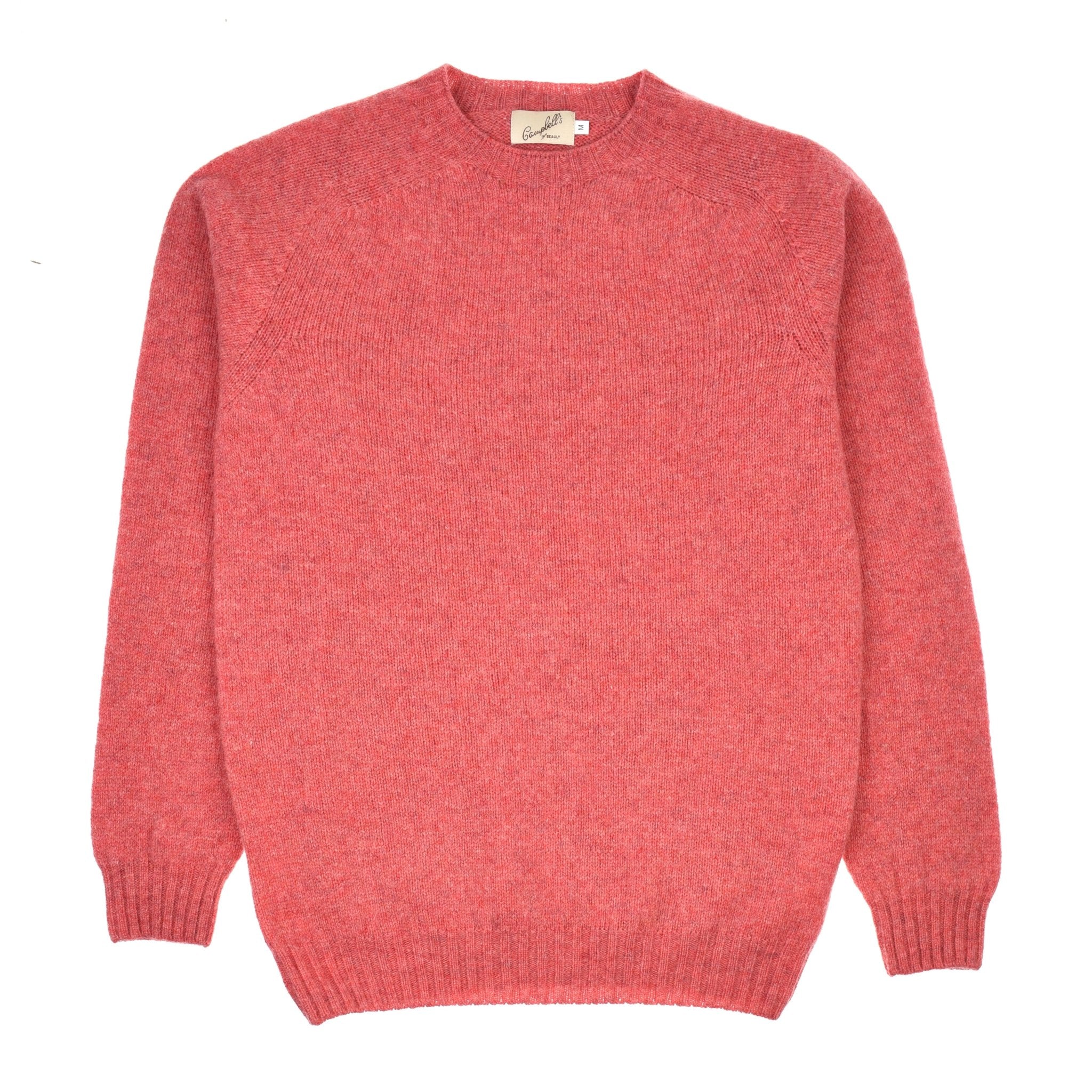 The Campbells of Beauly Shetland Jumper is a plain, long-sleeved crew neck crafted from soft, textured pinkish-red lambswool yarns and shown laid flat on a white background.