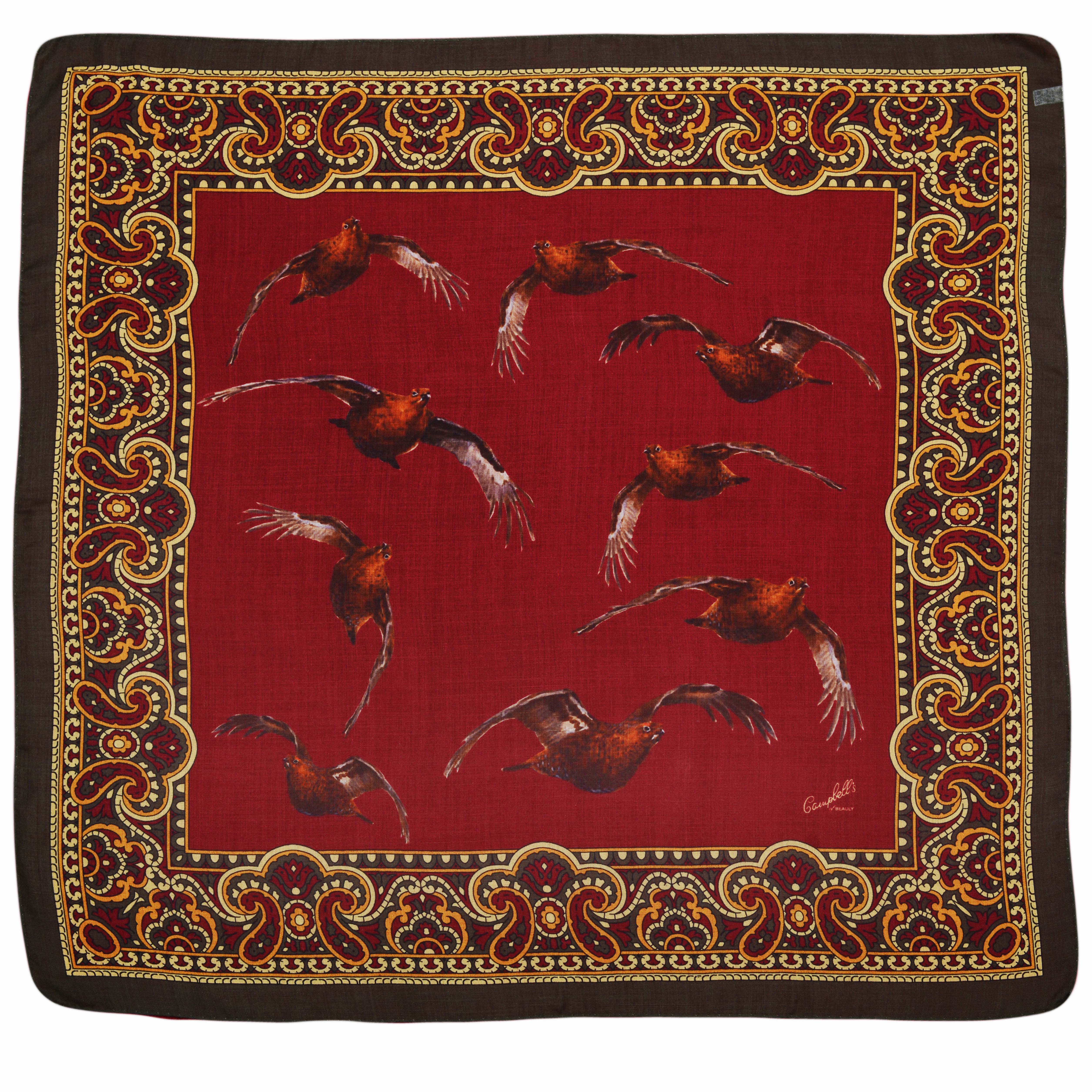 The Wool & Silk Hank by Campbells of Beauly is a square pocket square with a dark patterned border, red center featuring brown birds in flight, framed by gold, red, and black paisley designs, and refined hand-rolled edges.