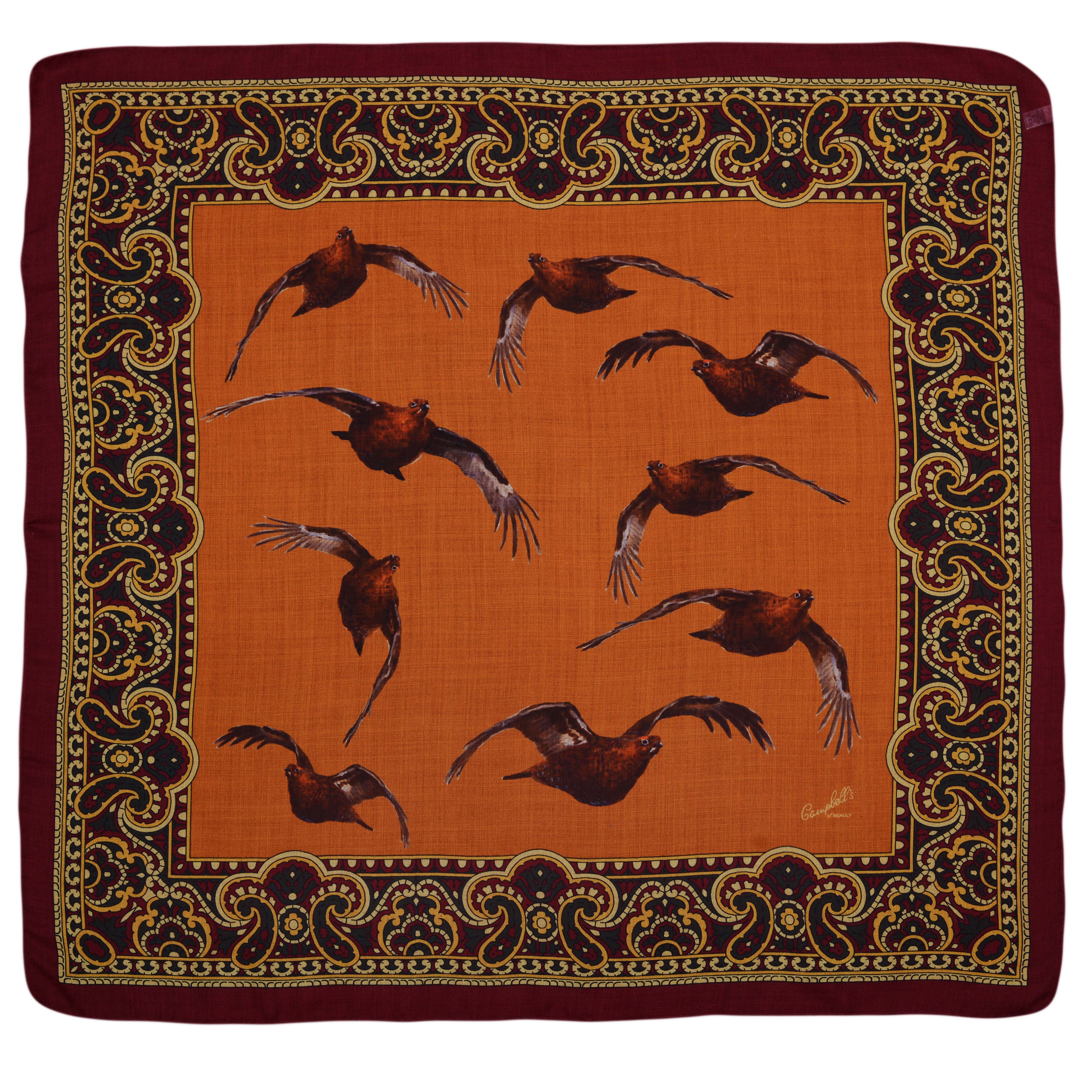 The Wool & Silk Hank by Campbells of Beauly is a square scarf with a striking orange center, bordered by maroon and gold paisley. Hand-rolled edges frame nine brown birds in dynamic flight, evoking the charm of classic pocket squares.