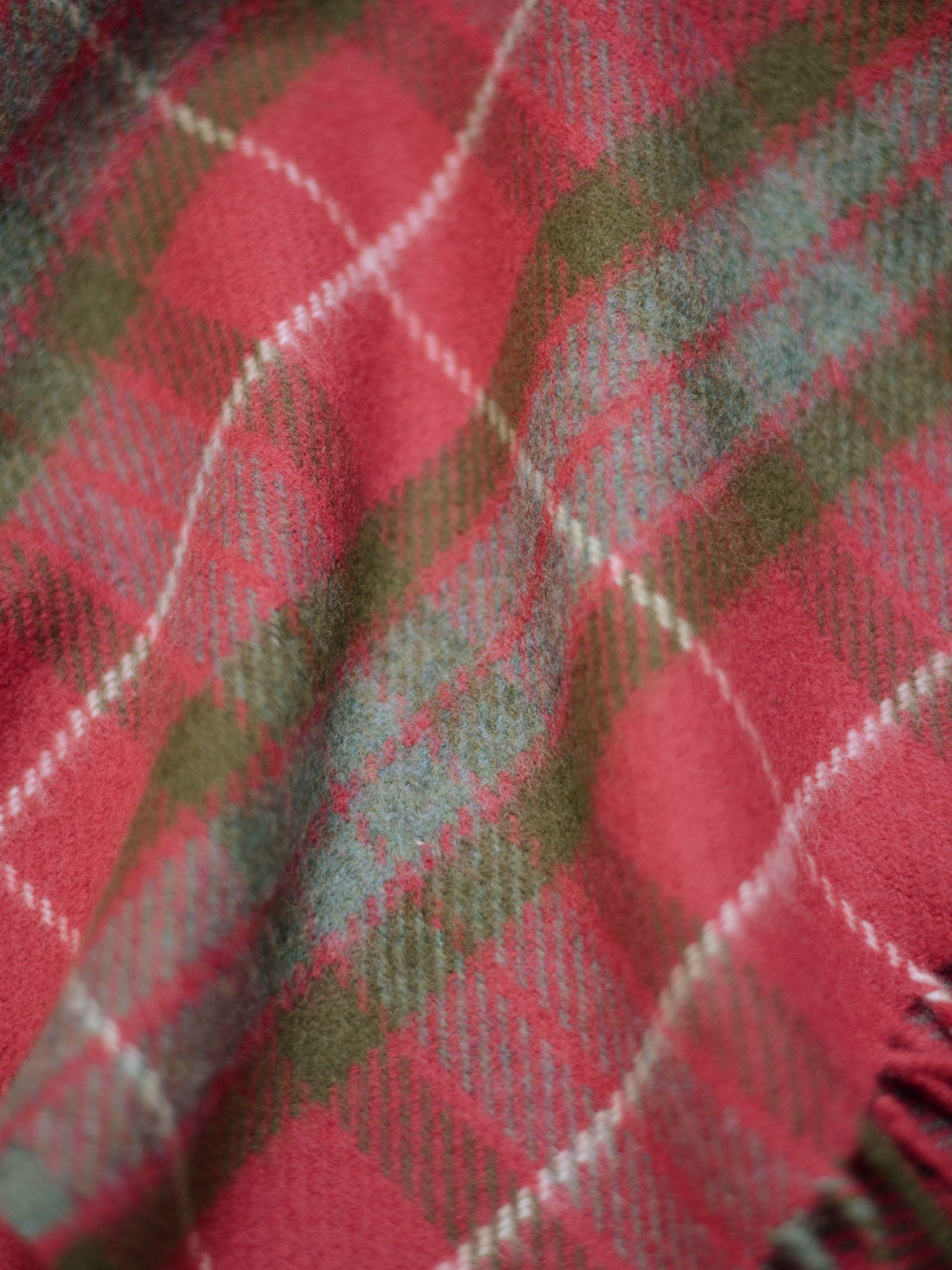 Close-up of the Limited Edition Fraser Red Weathered Lambswool Throw by Campbell's of Beauly, featuring soft wool in a red, green, and gray plaid tartan with diagonal lines and intersecting squares for rich texture.