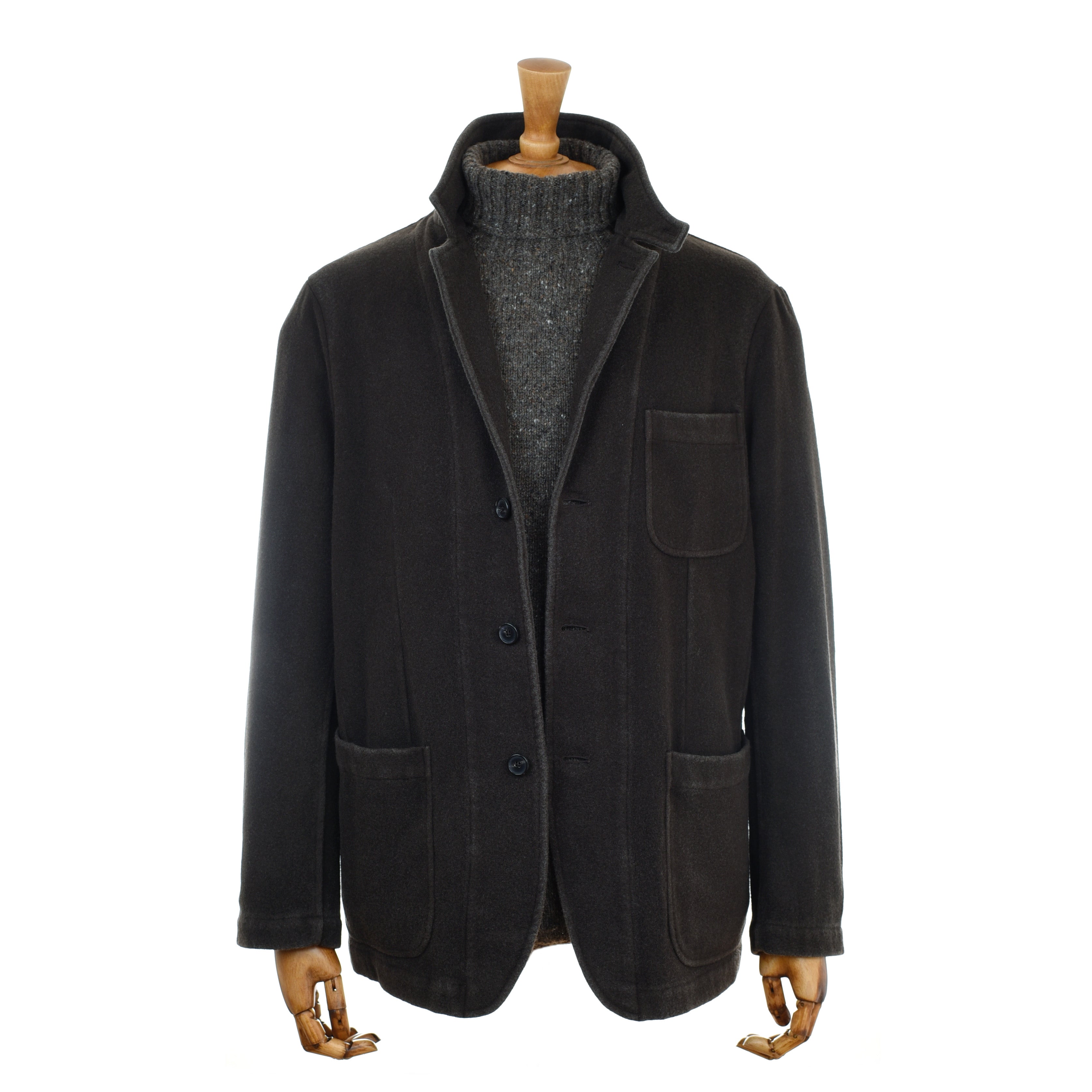 The Merino & Cashmere Jacket by Campbells of Beauly, in dark brown with buttons and three front pockets, is shown on a mannequin with wooden hands over a chunky dark gray turtleneck sweater against a plain white background.