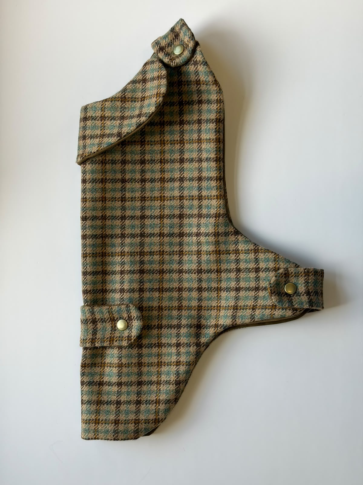 The Campbell's of Beauly House Tweed Dog Coat M is displayed flat against a white background. This dog coat showcases a checkered pattern in shades of brown, green, and blue, and is fastened with snaps.