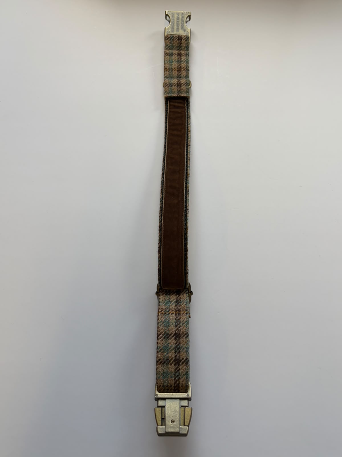 A brown and plaid House Tweed Dog Collar by Campbell's of Beauly, featuring metal clips on both ends, is laid flat on a white background.