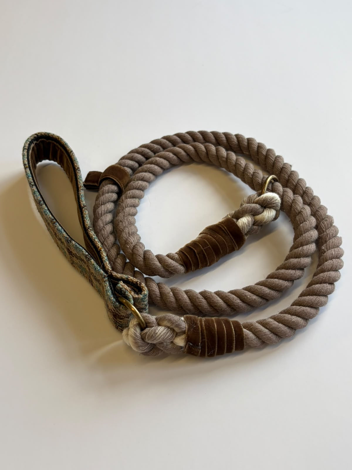 A House Tweed Slip Lead by Campbell’s of Beauly, featuring a coiled, thick rope design with brown leather accents and a looped handle, is shown resting on a plain white surface.