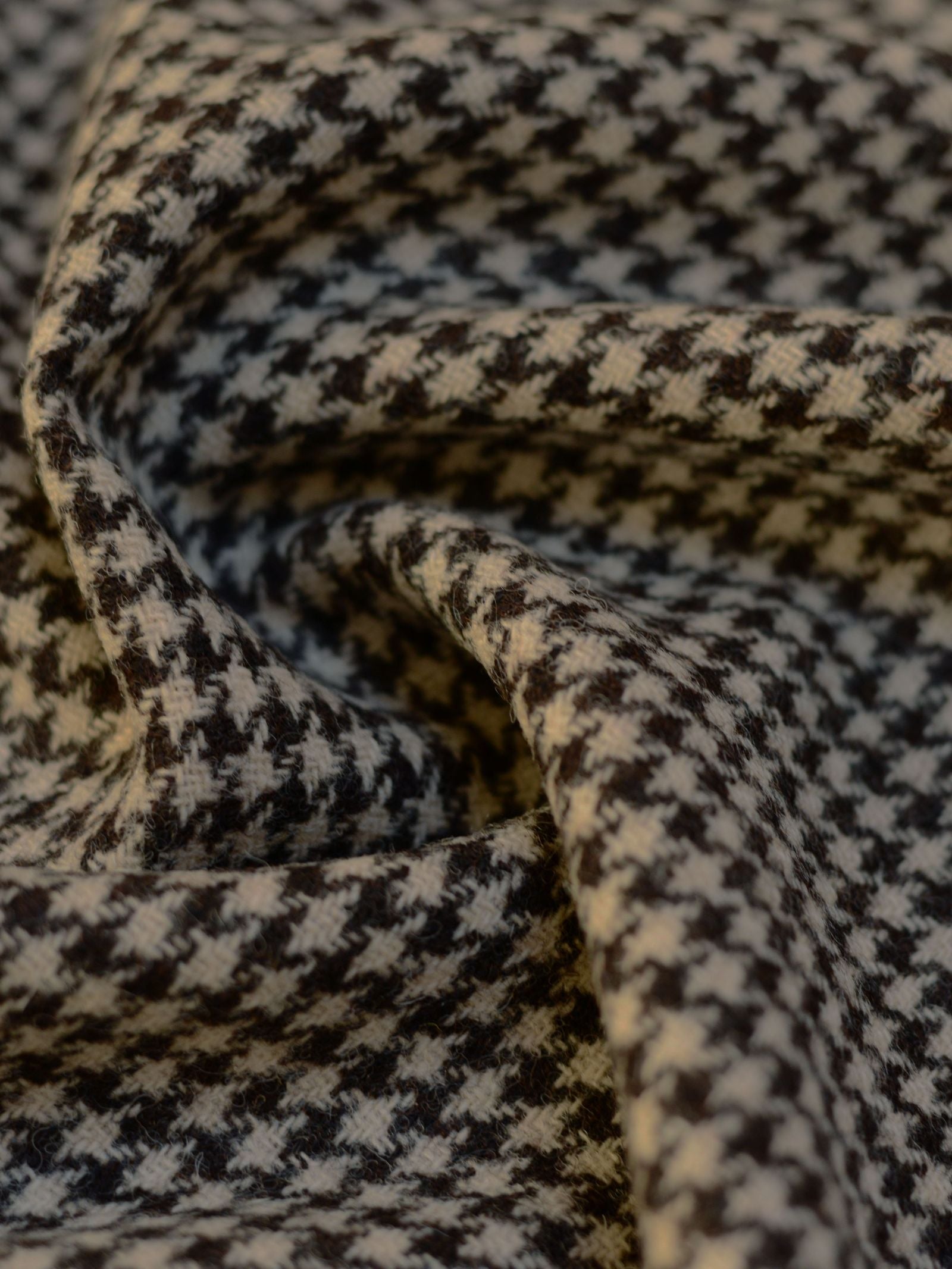 Close-up of House Tweed 93898 by Campbell's of Beauly: black and white houndstooth fabric with soft folds, highlighting its featherweight feel and honoring Scottish weaving heritage.