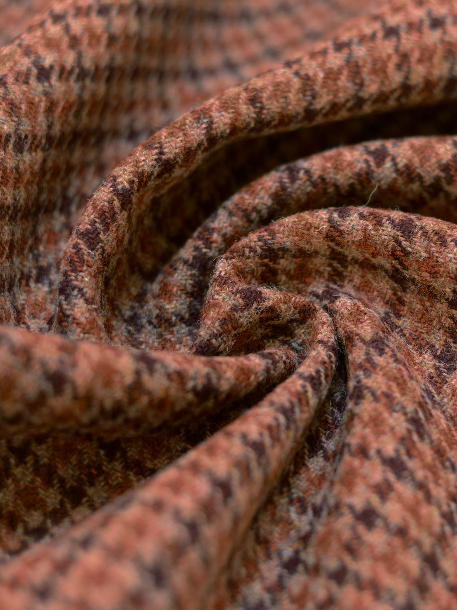 Close-up of soft, folded House Tweed 93910 fabric by Campbell's of Beauly in brown and black houndstooth, highlighting the texture and detailed weave inspired by traditional Scottish craftsmanship.