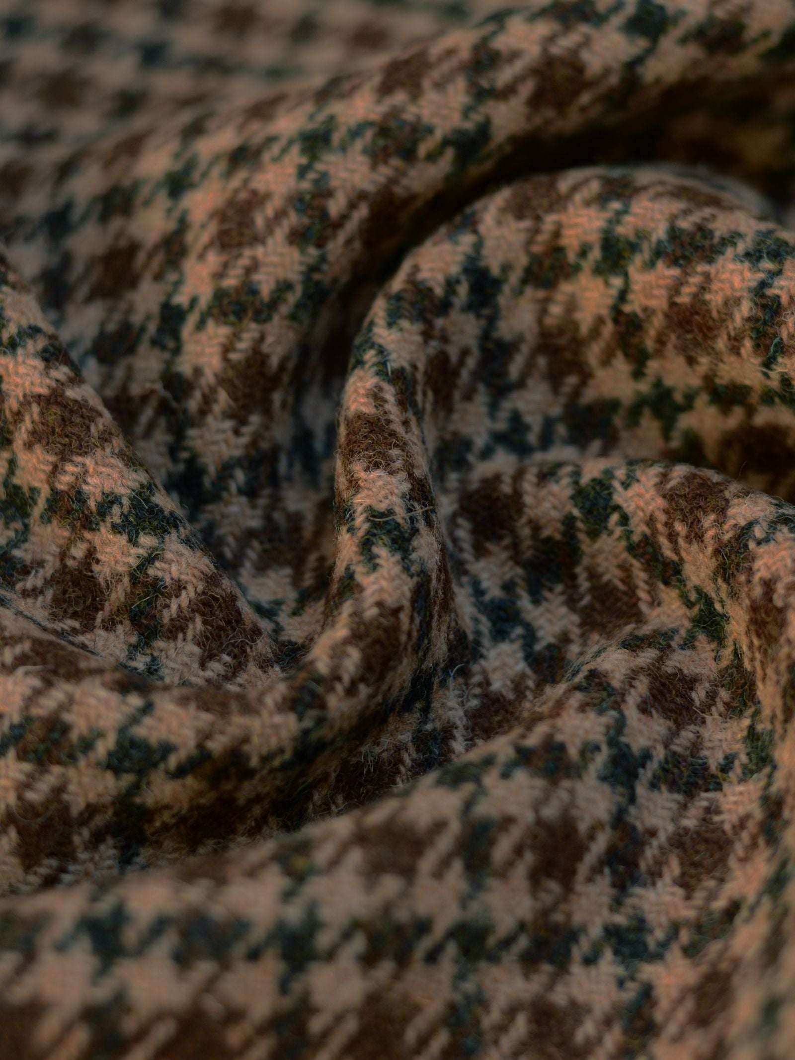 A close-up of House Tweed 93912 by Campbell's of Beauly, featuring a houndstooth pattern in brown, beige, and green tones that highlights its soft texture and intricate featherweight Scottish weave.