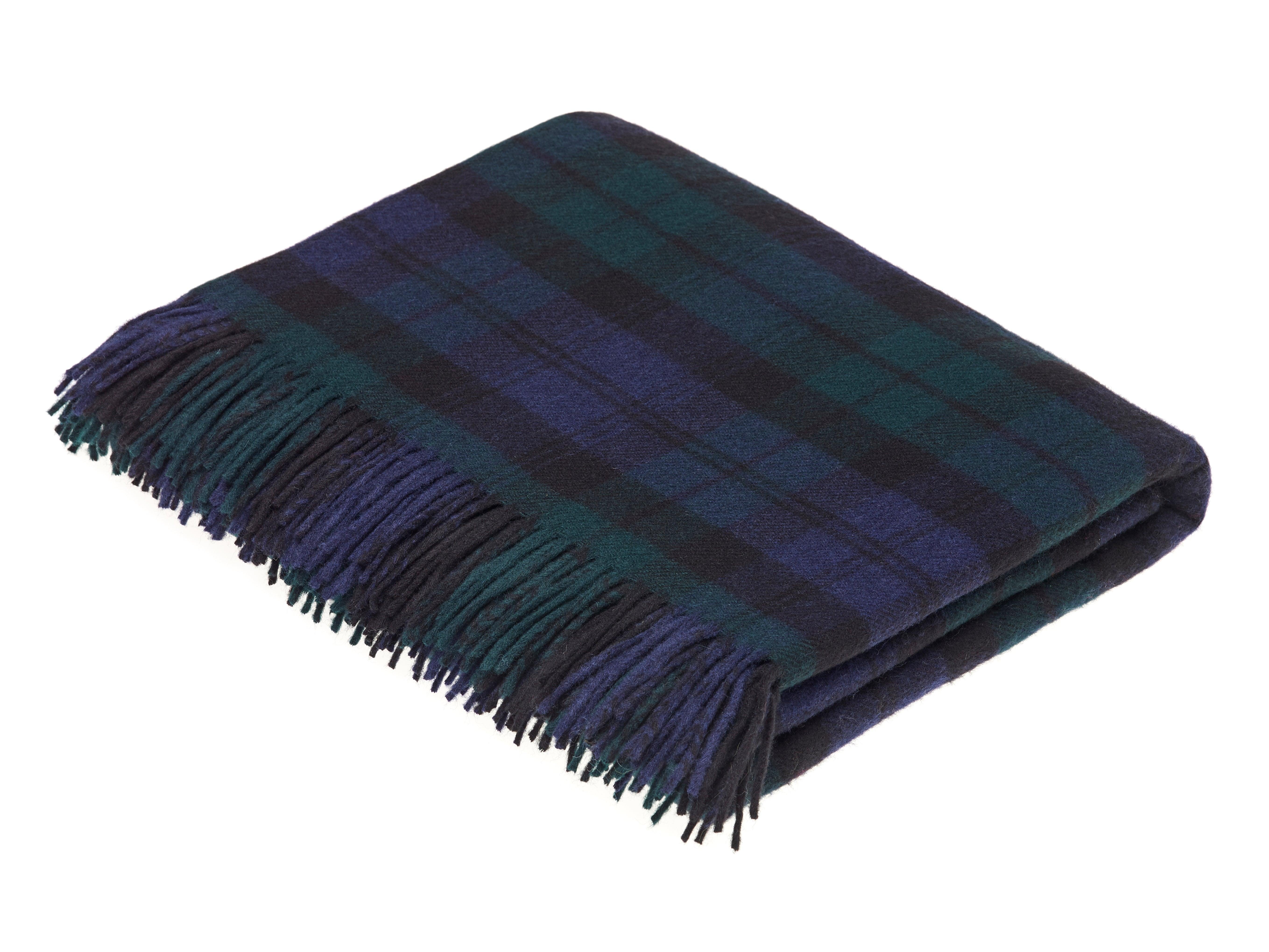 The Campbells of Beauly Blackwatch Tartan Lambswool Blanket features a classic dark green and navy blue checkered design with fringed ends, showcasing its soft, textured fabric in a neatly folded display.