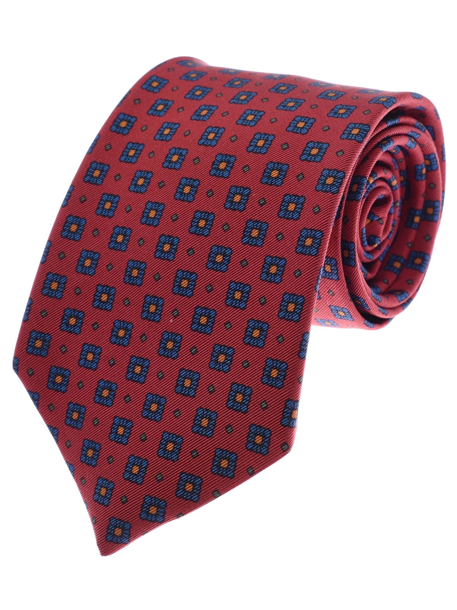 A Paisley Silk Tie from Campbell’s of Beauly, featuring a red base with a repeating blue and yellow geometric square pattern, is rolled up neatly on a white background—an excellent example of UK-made ties crafted with precision and elegance.