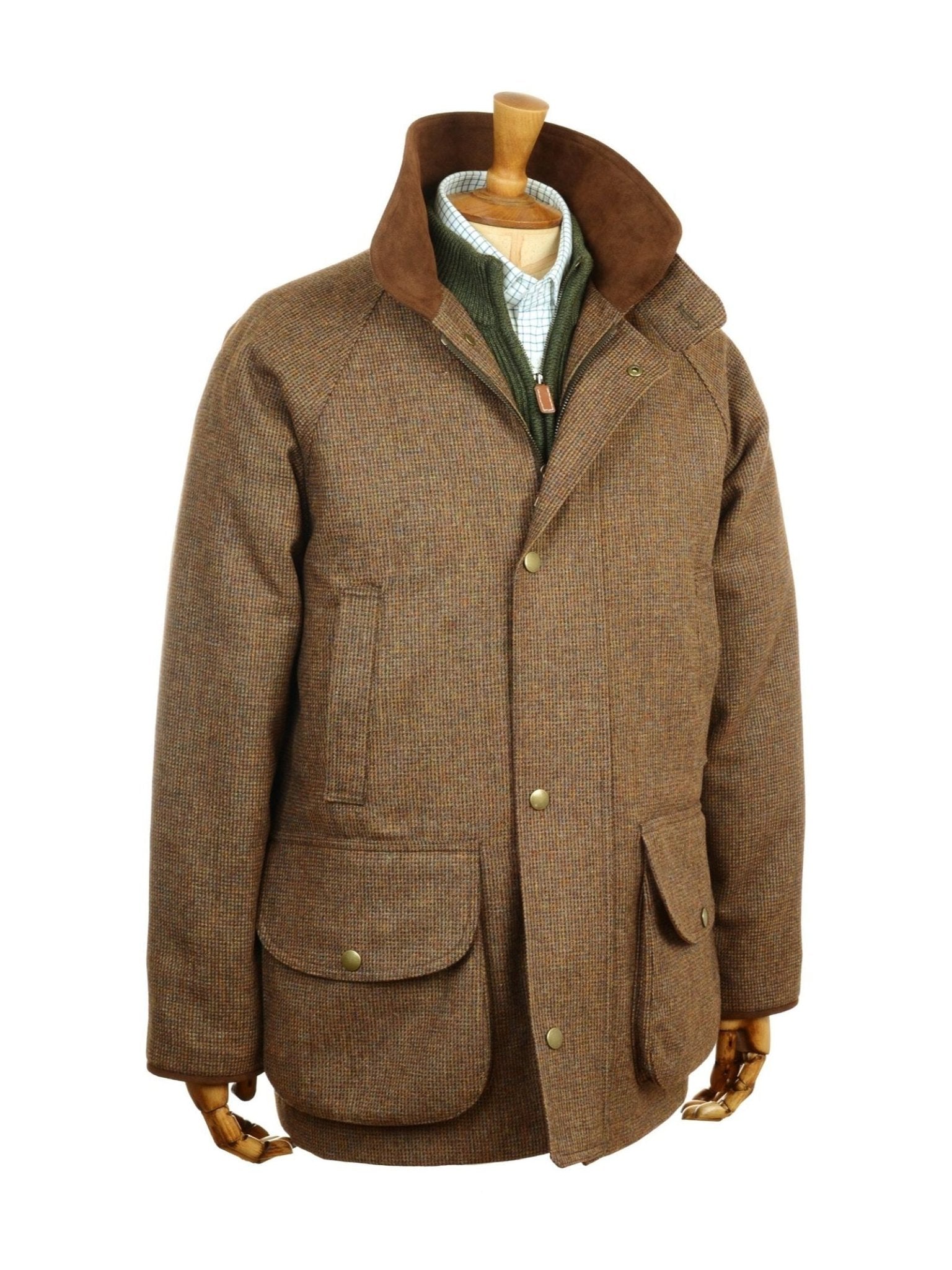 The Campbell’s of Beauly Tweed Field Coat, expertly crafted in the UK, features brown tweed fabric, large front pockets, button closure, and a corduroy collar. It is shown on a wooden mannequin layered over a green zip-up sweater.