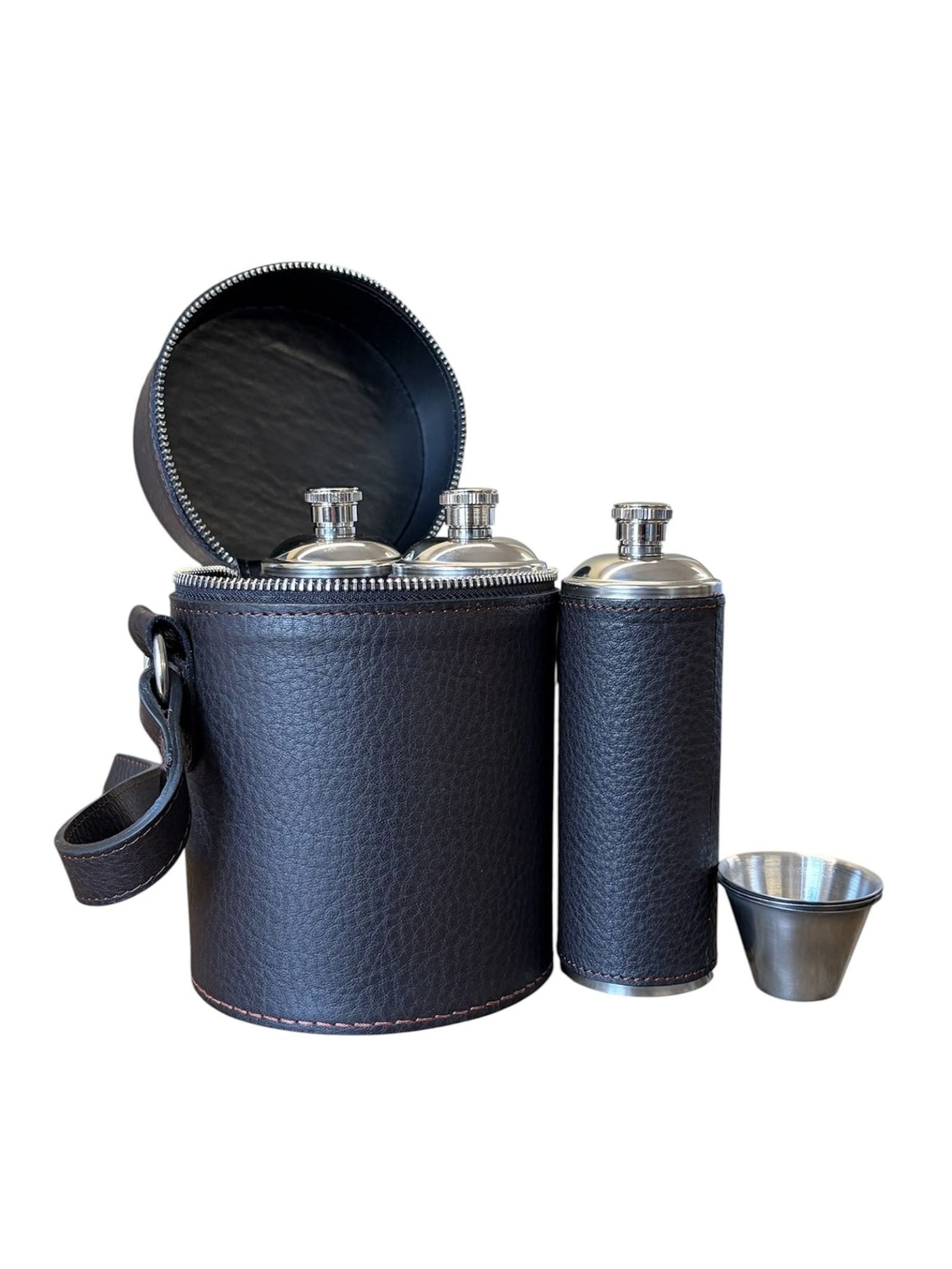 Campbell’s of Beauly Triple Flask Set—a black leather cylindrical case with a zipper containing three stainless steel flasks, ideal for outdoor enthusiasts—comes with a metal shot glass placed beside it.
