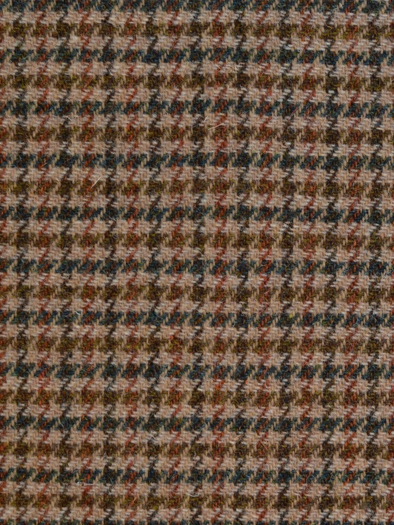 Close-up of House Tweed 93887 by Campbell's of Beauly, showing a dense houndstooth weave in brown, tan, black, and cream with small jagged shapes.