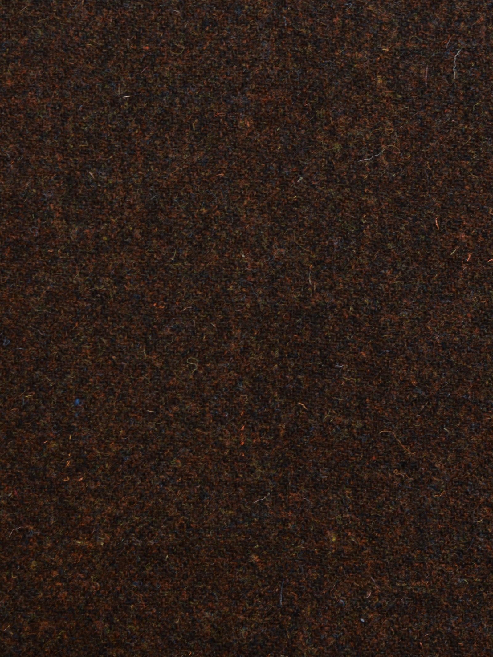 Close-up of House Tweed 93893 by Campbell's of Beauly, a dark brown, textured Harris Tweed wool fabric with a slightly mottled look and visible fibers, highlighting traditional Scottish weaving craftsmanship.