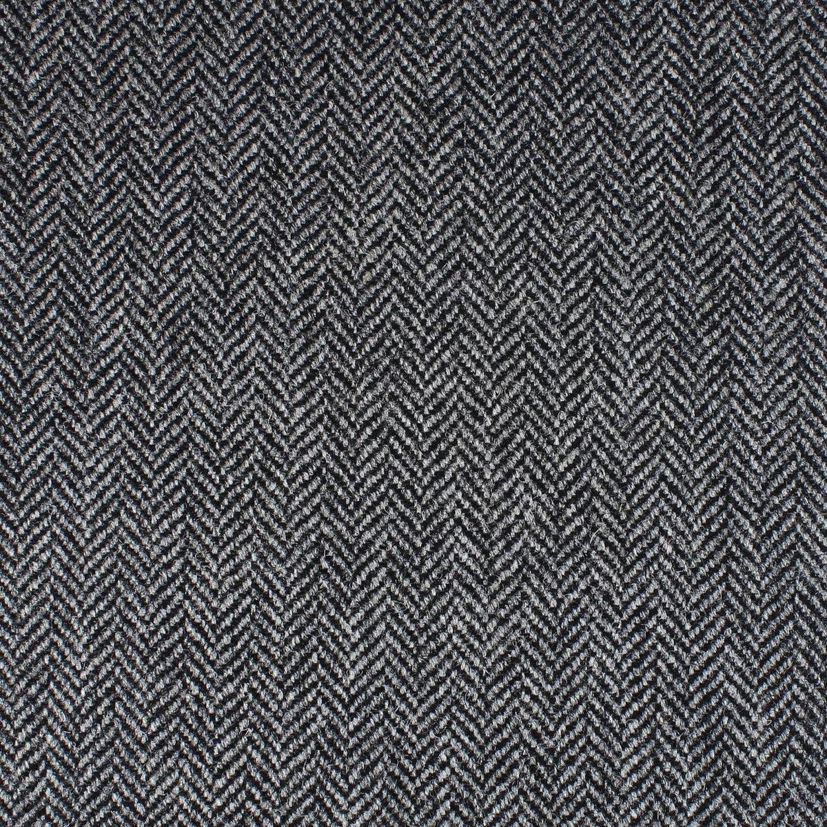 Close-up of a dark grey and black herringbone patterned Field Tweed 112 by Lovat Mill.