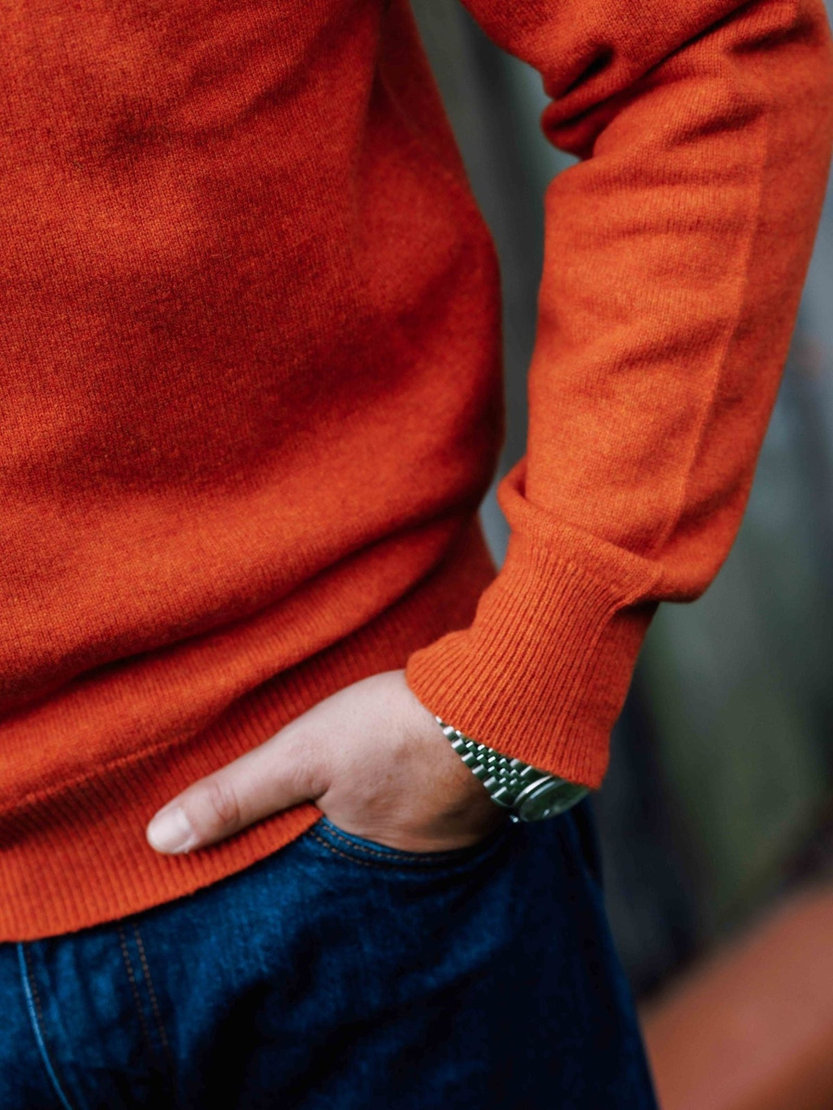 A person wearing a Campbell’s of Beauly Lambswool Crew Neck Jumper and blue jeans with their hand in their pocket, showing a metallic wristwatch.