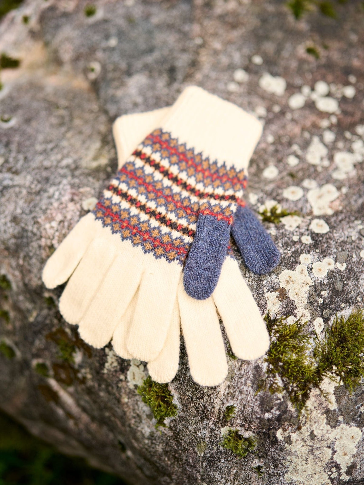 Campbell’s of Beauly Lambswool Fairisle Gloves in cream with a multicolored Fair Isle pattern around the cuffs and contrasting blue thumbs.