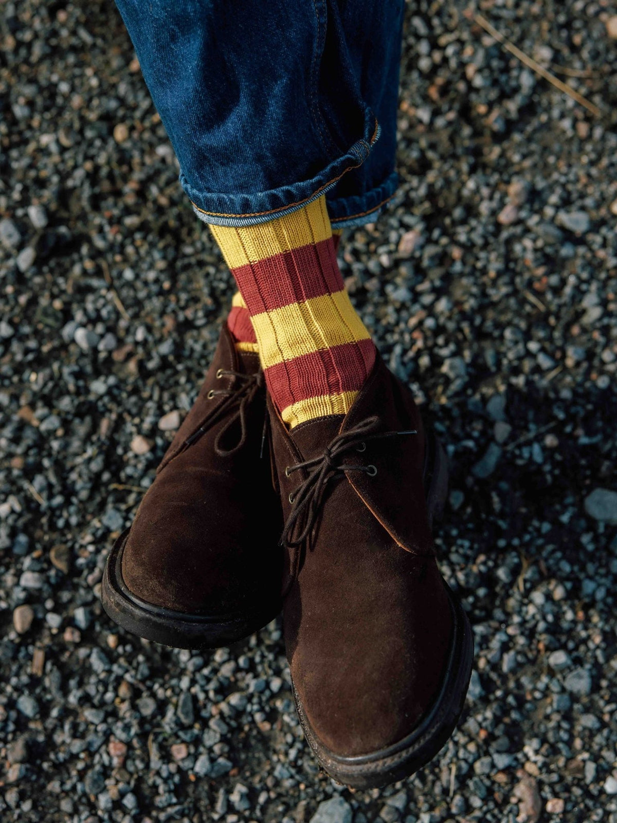 Campbell’s of Beauly Lomond Boots in chocolate brown suede with a Goodyear welted construction, worn with red and yellow striped socks and cuffed blue jeans.