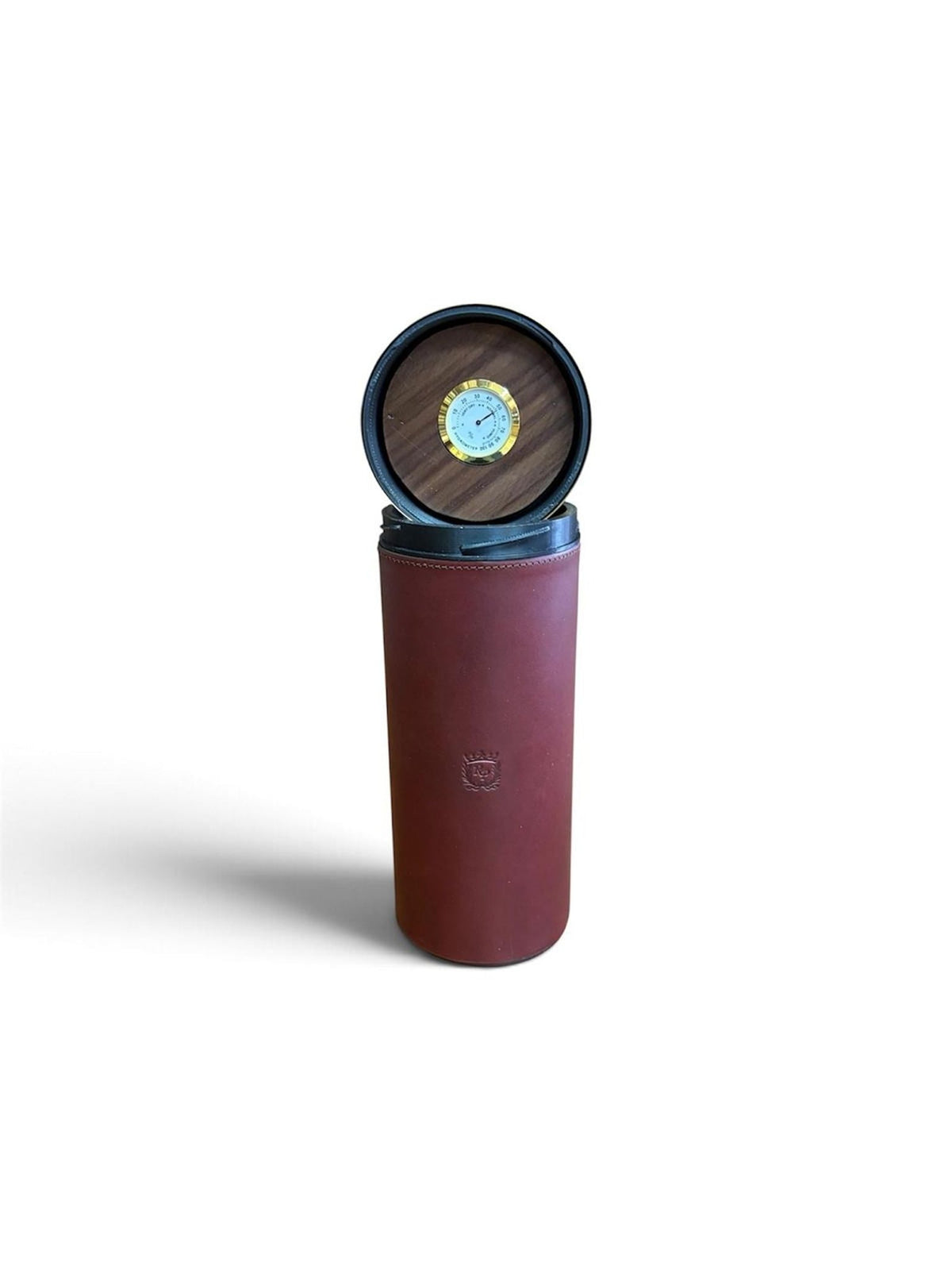 The Rey Pavón Shotgun Cartridge Cigar Humidor features a cylindrical brown leather design with a black lid, which opens to reveal a round gauge or hygrometer set in wood on the inside of the lid. Its cedar-lined interior ensures optimal conditions for storing your cigars, making this humidor an ideal choice for aficionados.